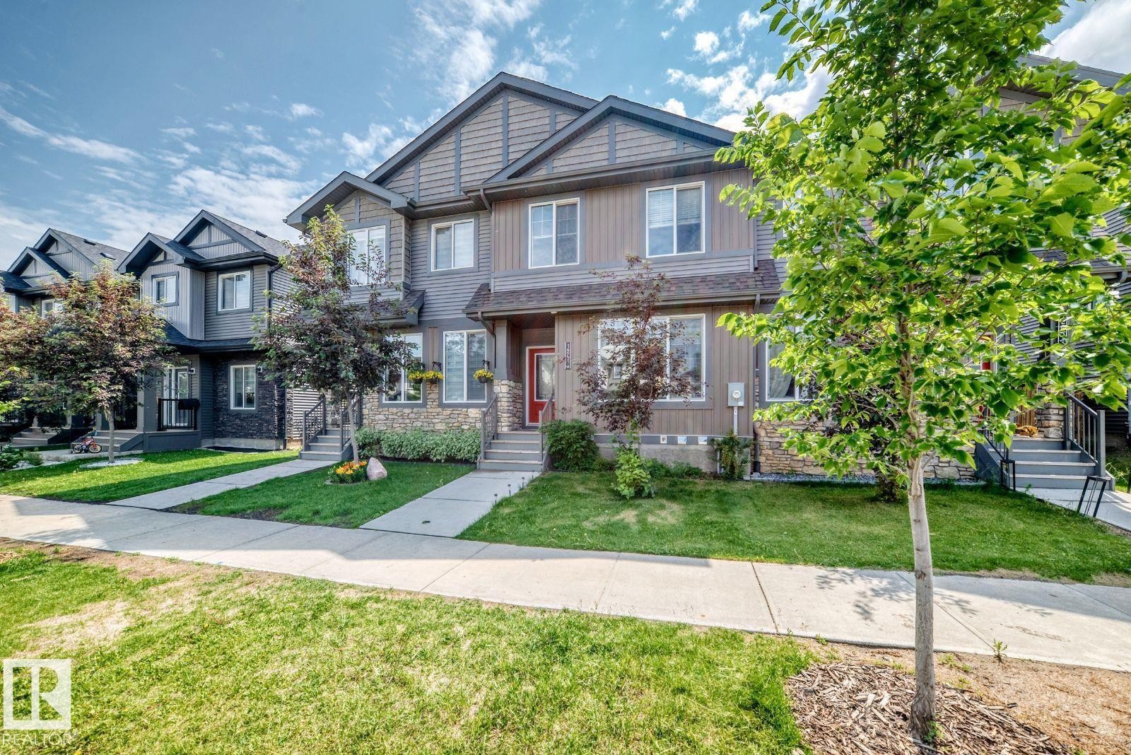 Contemporary townhome exterior featuring multi-level construction, stone accents, and varied siding - 1261 Rosenthal Boulevard Nw, Edmonton, AB - Outdoor With Facade