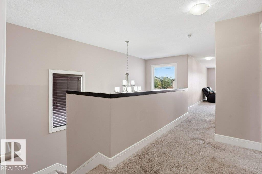 Upper-level hallway featuring neutral-toned carpeting, light gray wall paint, and white baseboards - 258 Albany Drive Nw, Edmonton, AB - Indoor Photo Showing Other Room