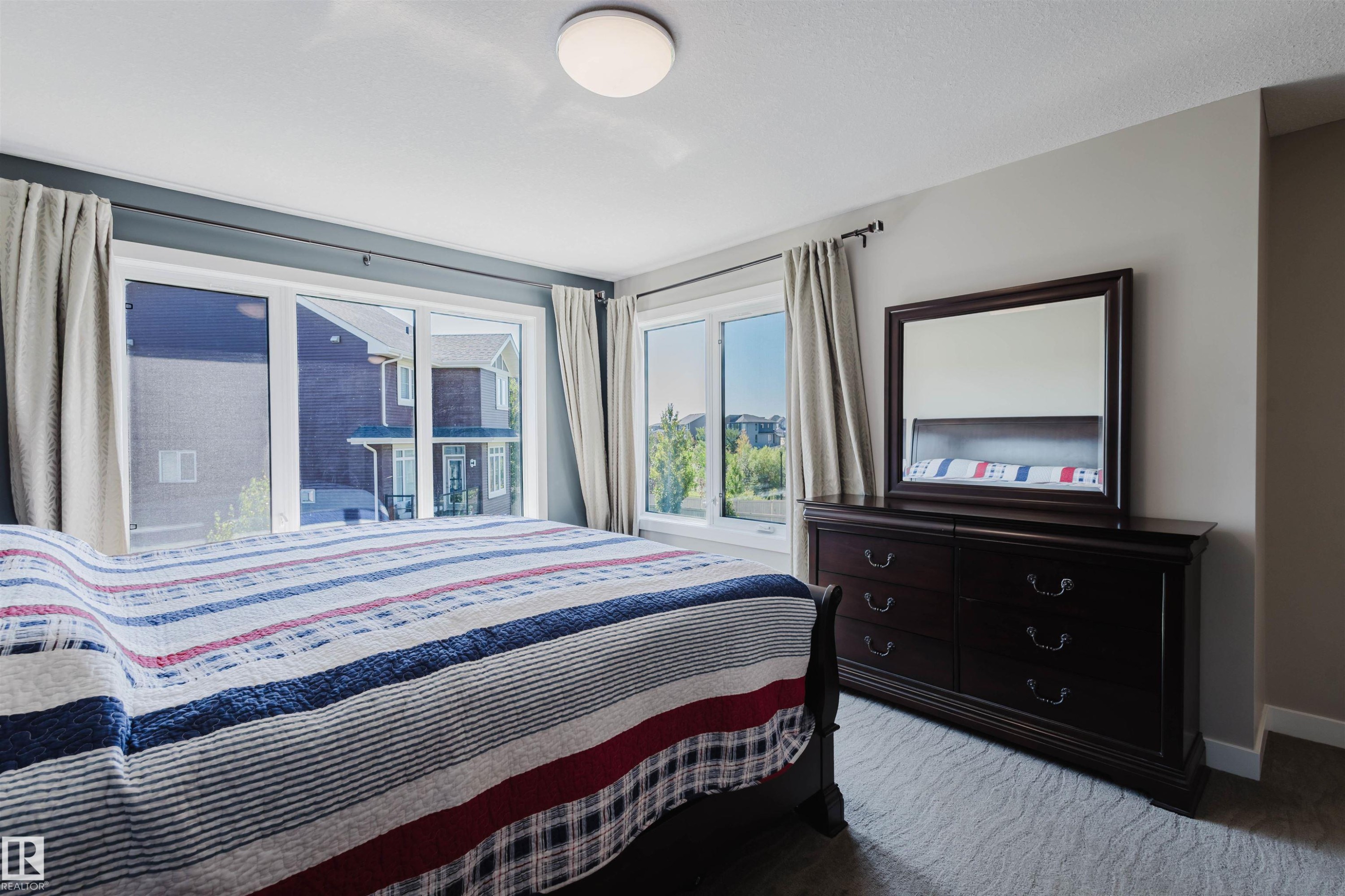 Room with broad windows, light gray walls, and textured carpet flooring - 4125 Kennedy Green Sw, Edmonton, AB - Indoor Photo Showing Bedroom