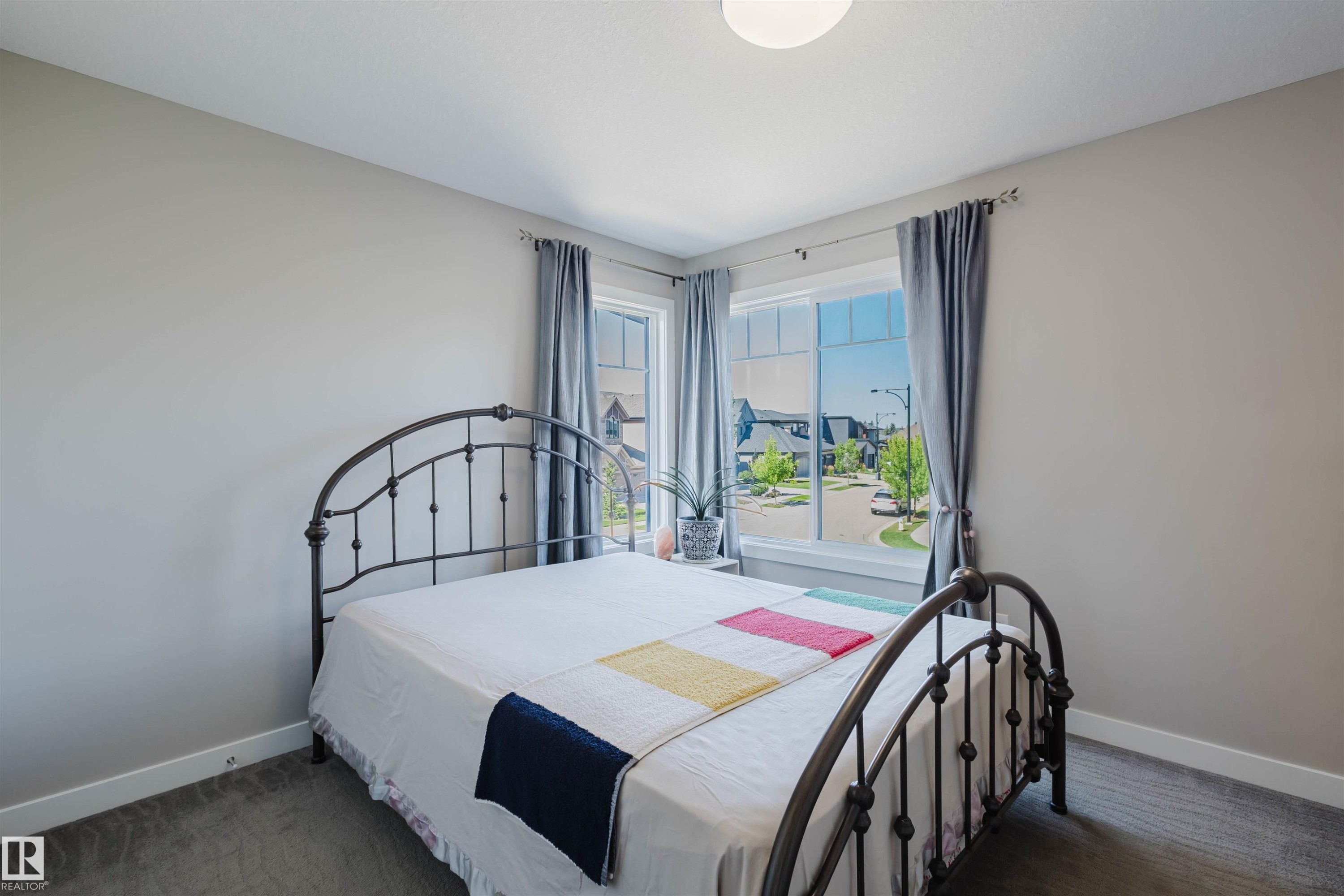 Spacious room featuring neutral paint, soft grey carpet, and white baseboards - 4125 Kennedy Green Sw, Edmonton, AB - Indoor Photo Showing Bedroom