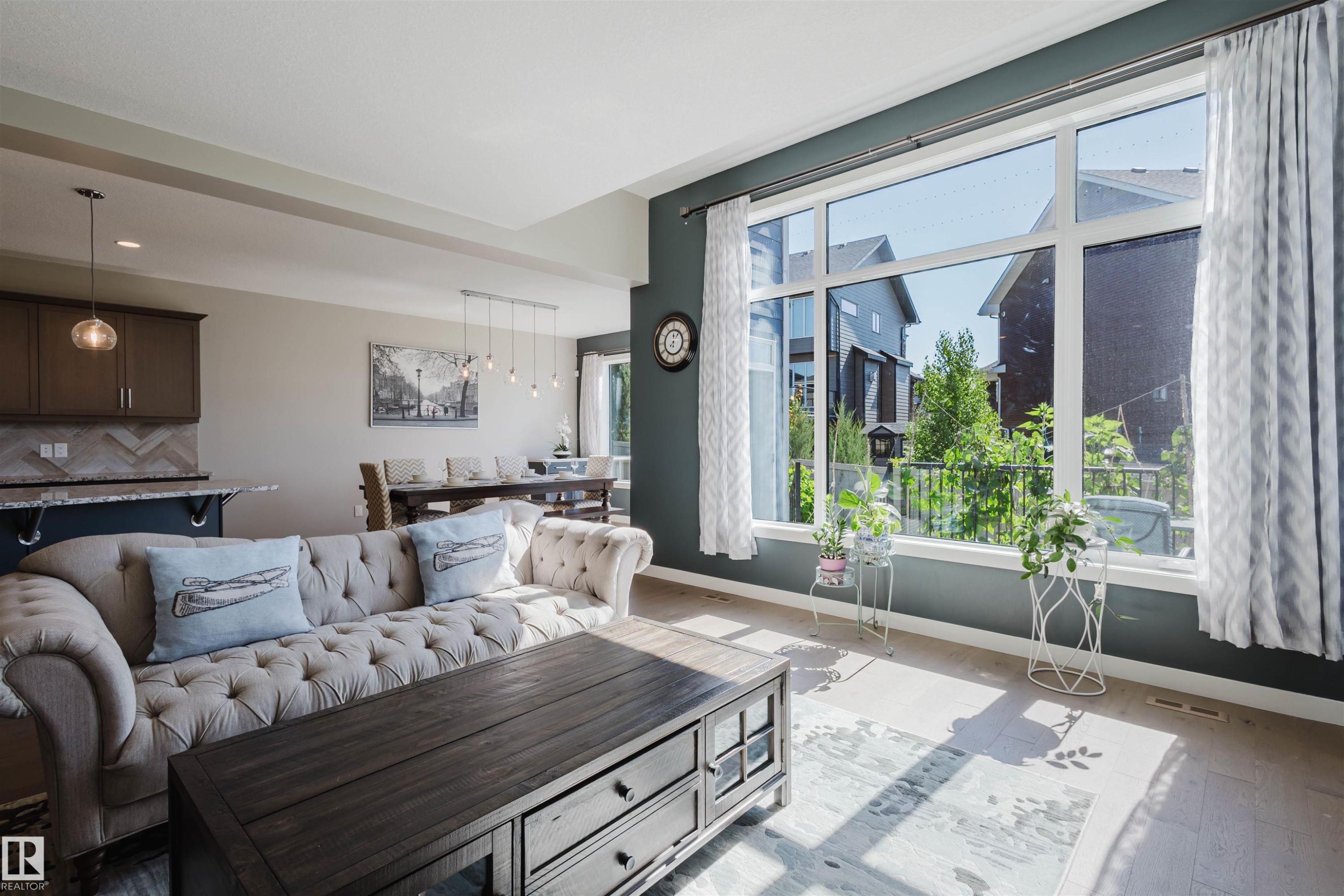 Living area featuring a large picture window with multiple panes, providing natural illumination - 4125 Kennedy Green Sw, Edmonton, AB - Indoor Photo Showing Living Room