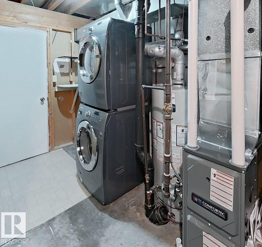 Utility area featuring a stacked washer and dryer, water heater, and furnace - 60 Northwoods Village Nw, Edmonton, AB - Indoor Photo Showing Laundry Room