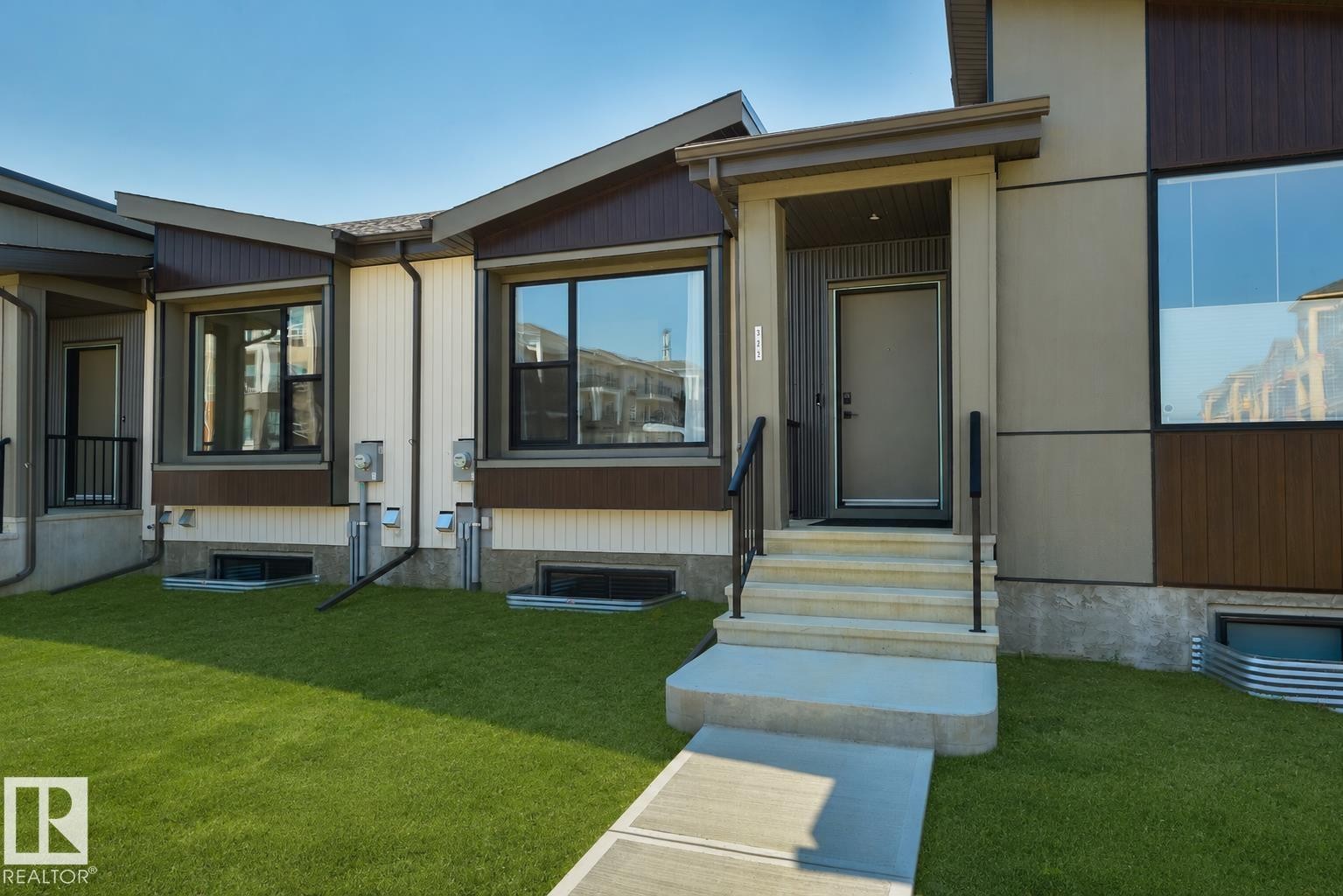 Contemporary exterior featuring a covered entry, concrete steps with black railings, and a full-light entry door - 323 Rankin Drive, St. Albert, AB - Outdoor