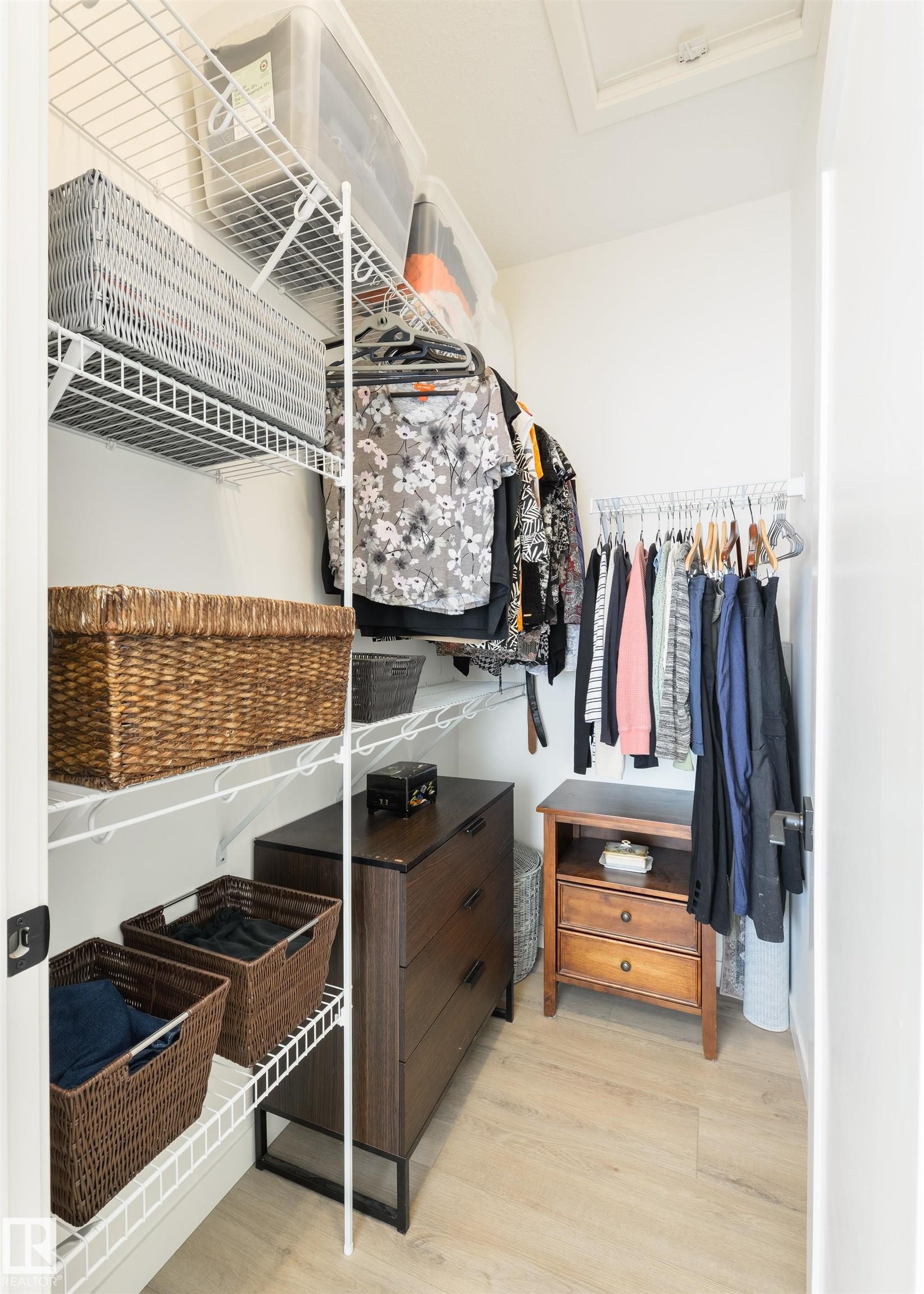 Walk-in closet featuring light wood-finish flooring, white wire shelving, and multiple clothing racks - 323 Rankin Drive, St. Albert, AB - Indoor With Storage