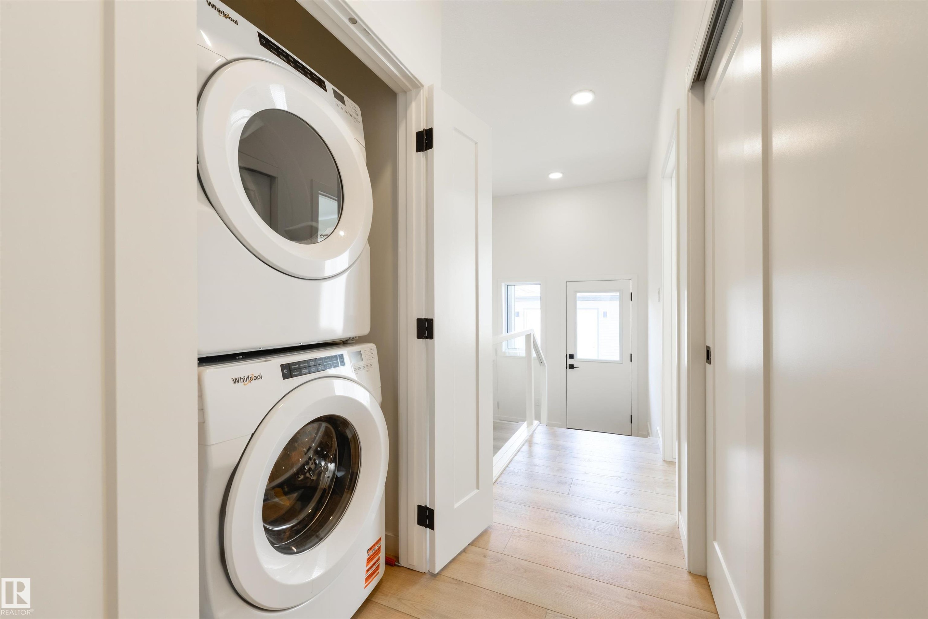 Integrated stacked laundry appliances within a hallway closet - 323 Rankin Drive, St. Albert, AB - Indoor Photo Showing Laundry Room