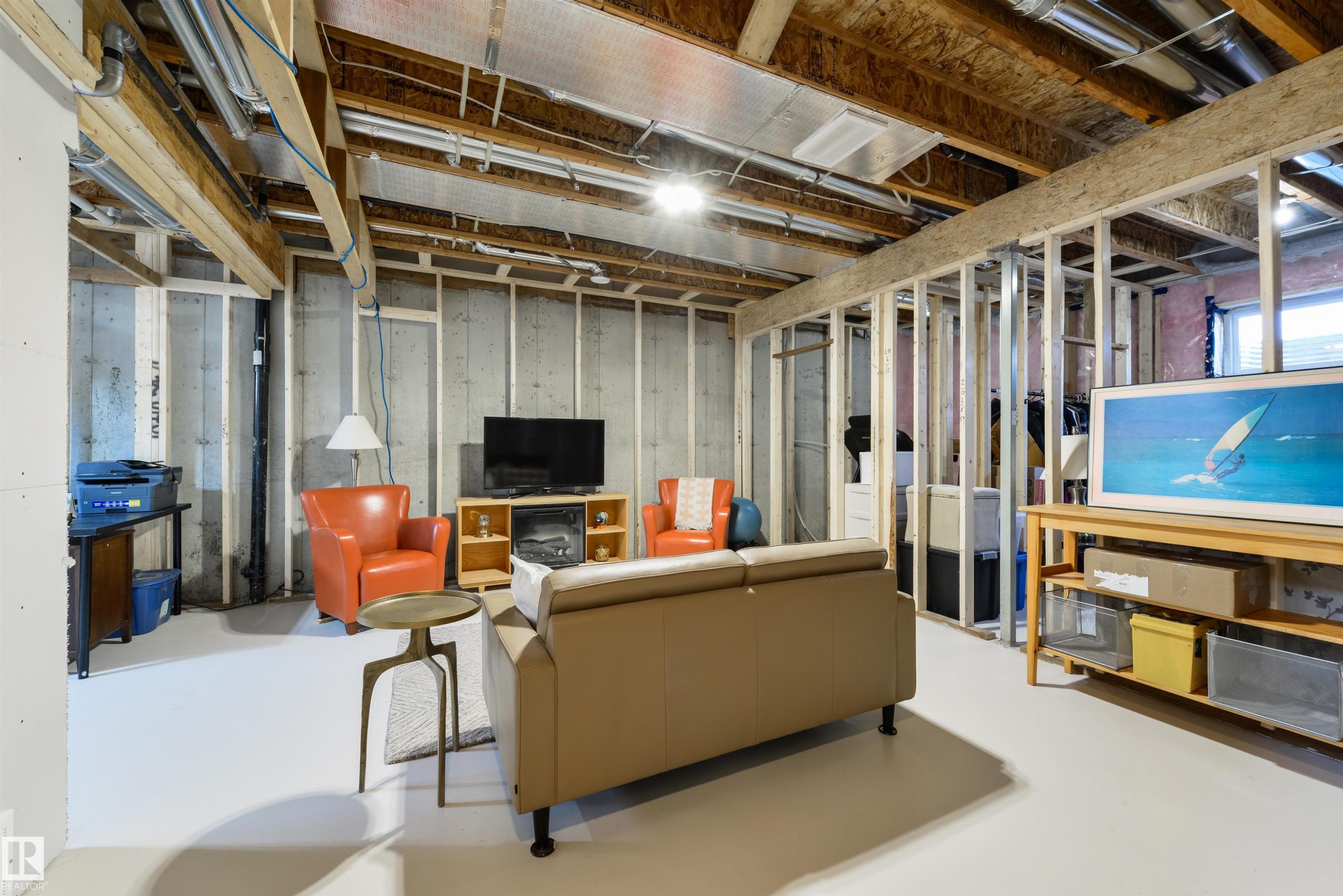 Unfinished basement framing with exposed concrete walls, painted concrete flooring, and visible ceiling joists - 323 Rankin Drive, St. Albert, AB - Indoor Photo Showing Basement