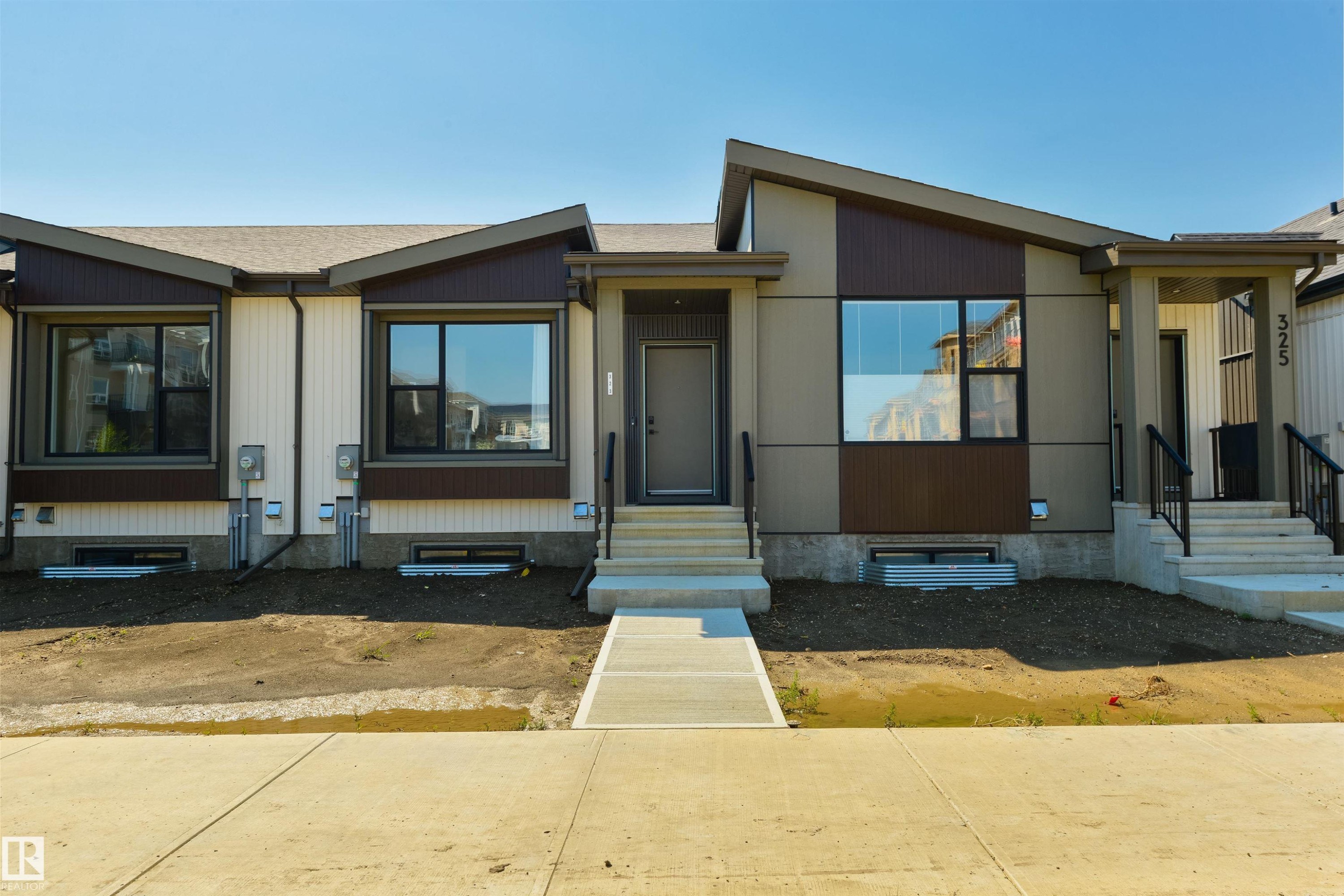 Modern multi-family dwelling featuring a contemporary façade with contrasting vertical and horizontal siding panels - 323 Rankin Drive, St. Albert, AB - Outdoor With Facade