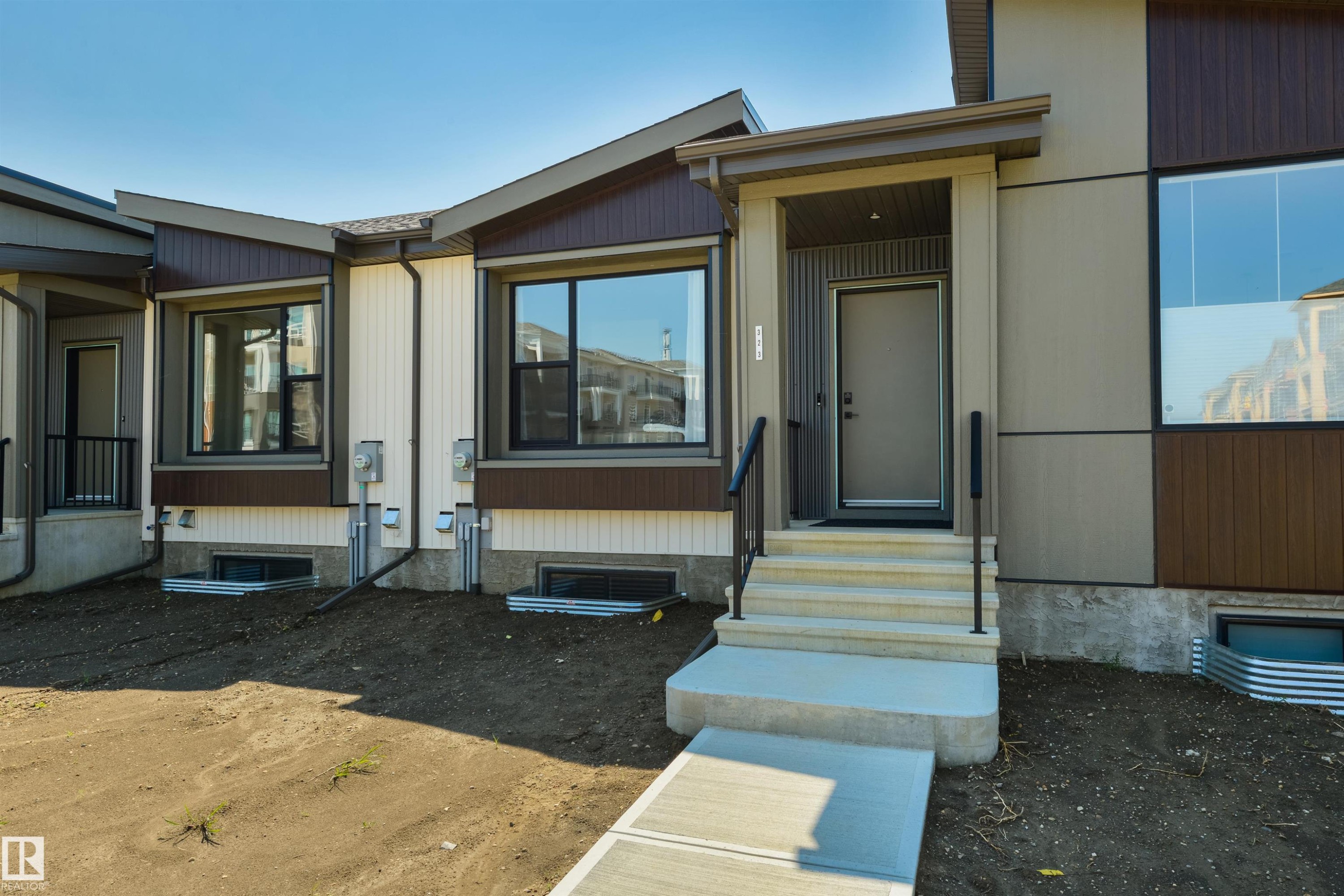 Modern facade featuring varied siding materials and prominent black-framed windows - 323 Rankin Drive, St. Albert, AB - Outdoor