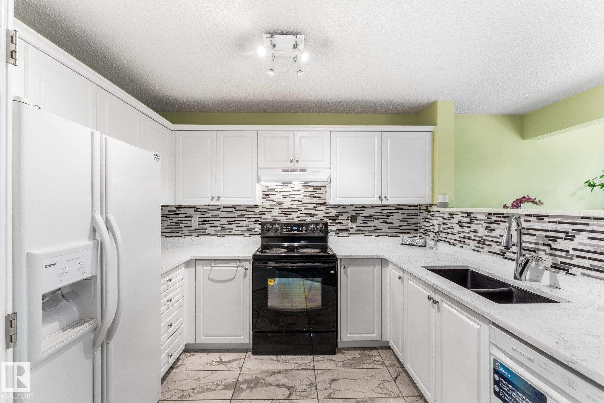 Updated ceramic tile, countertop and backplash. - 13148 151 Avenue Nw, Edmonton, AB - Indoor Photo Showing Kitchen With Double Sink With Upgraded Kitchen