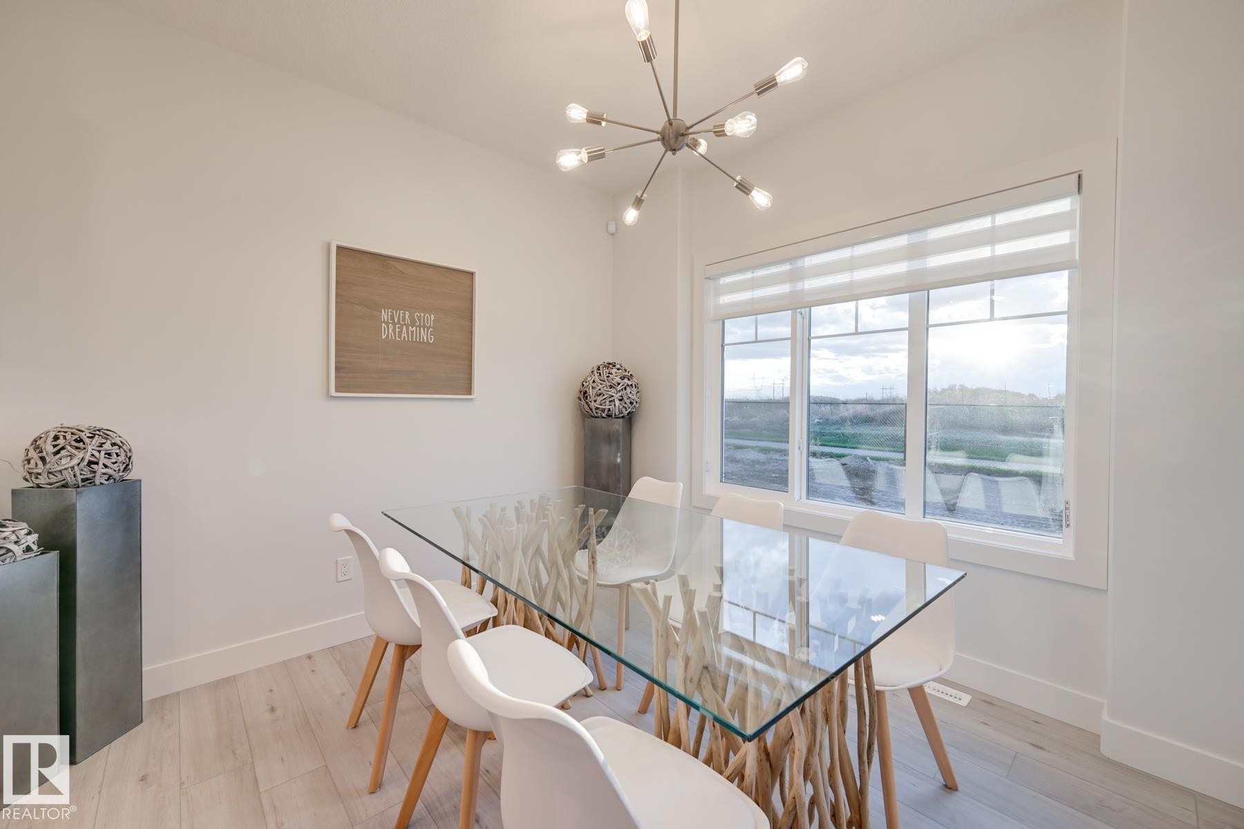 Dining area featuring a contemporary chandelier, large picture window with blinds, and light wood-finish flooring - 1776 Crossbill Loop Nw, Edmonton, AB - Indoor Photo Showing Dining Room
