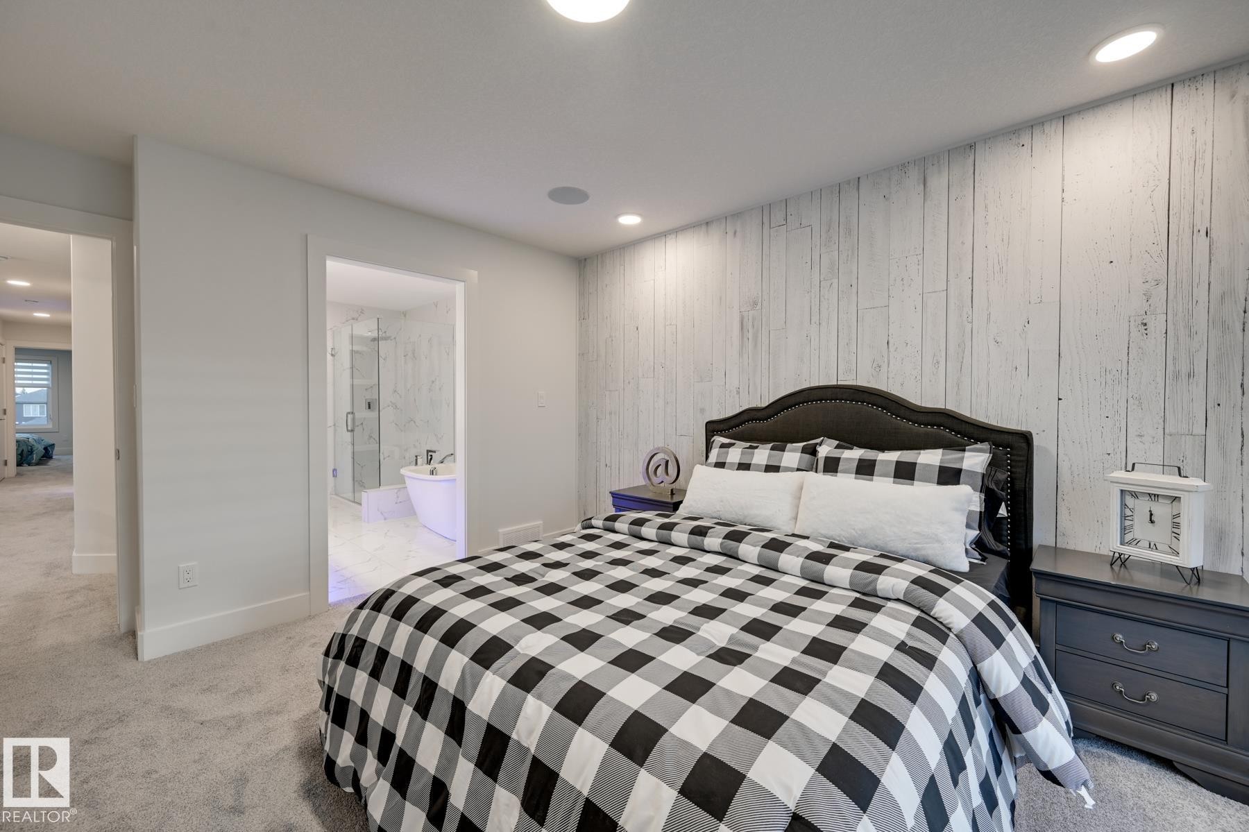 Bedroom featuring a distressed wood-look accent wall, recessed lighting, and light grey carpeting - 1776 Crossbill Loop Nw, Edmonton, AB - Indoor Photo Showing Bedroom