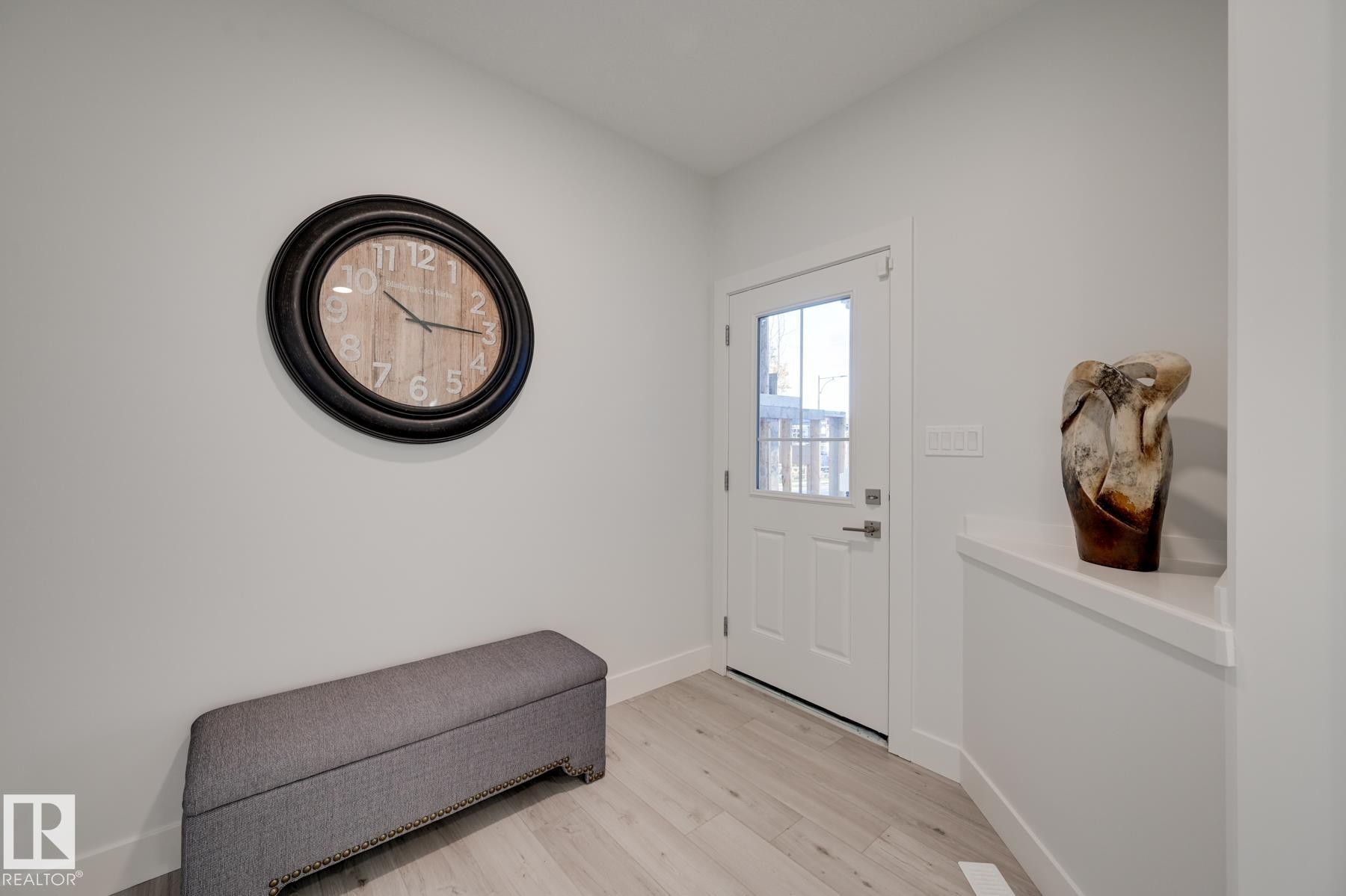 Entryway featuring a solid white door with an integrated window pane, modern hardware, and light wood-finish flooring - 1776 Crossbill Loop Nw, Edmonton, AB - Indoor Photo Showing Other Room