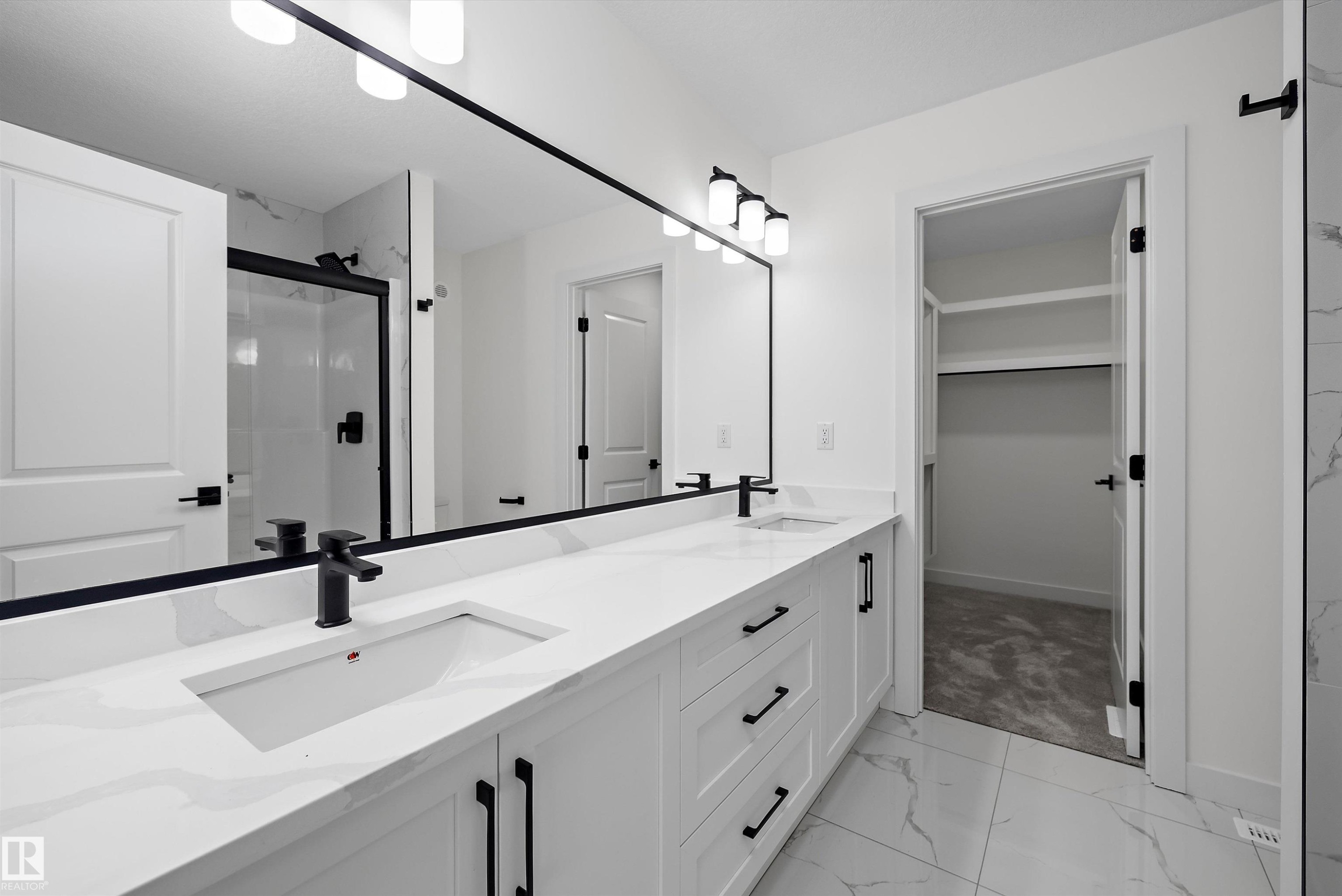 Primary bathroom featuring a dual-sink vanity with white cabinetry, quartz countertop, and matte black hardware - 1776 Crossbill Loop Nw, Edmonton, AB