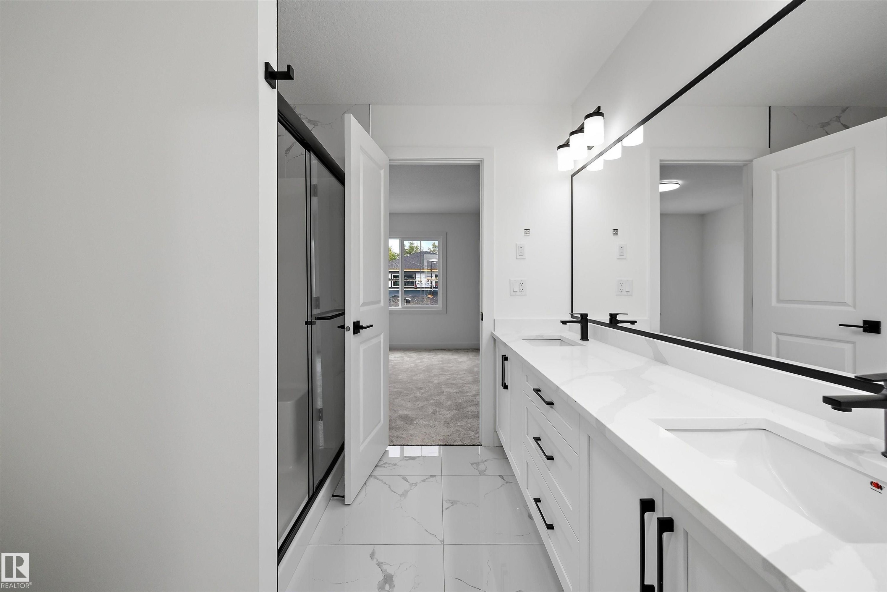 Dual vanity with white countertops and undermount sinks, frameless mirror, and black-framed glass shower enclosure - 1776 Crossbill Loop Nw, Edmonton, AB