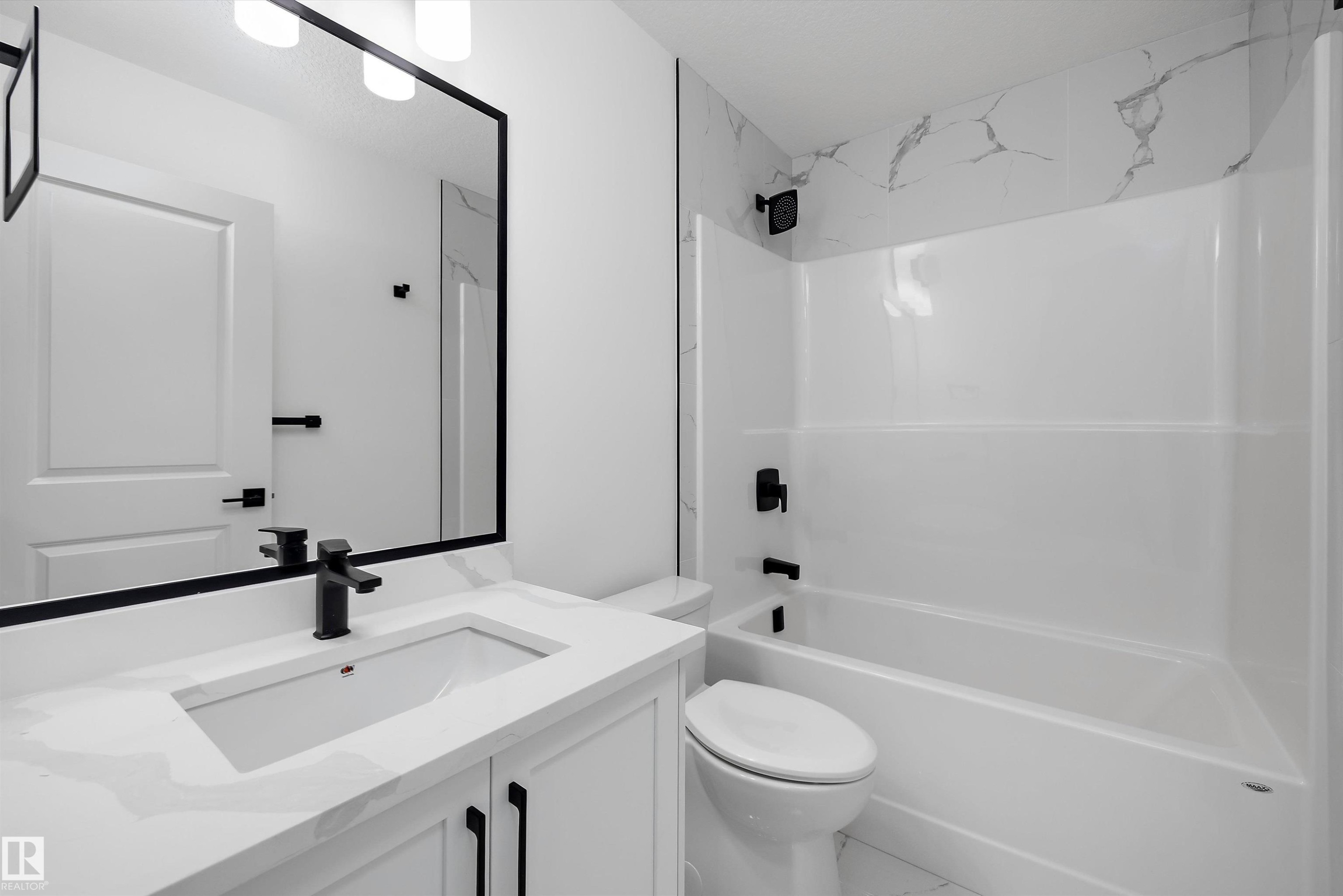 Modern bathroom featuring a floating vanity with rectangular undermount sink, white quartz countertop, and matte black faucet hardware - 1776 Crossbill Loop Nw, Edmonton, AB