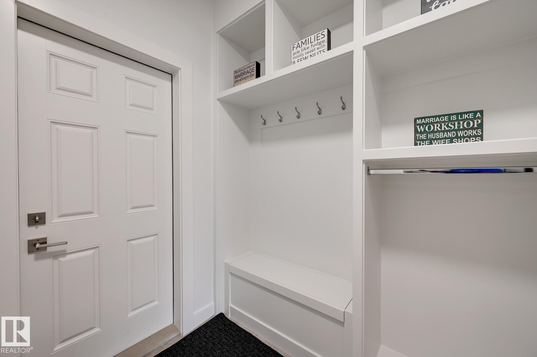 White paneled entry door with brushed nickel hardware, complemented by an integrated mudroom system - 1776 Crossbill Loop Nw, Edmonton, AB - Indoor