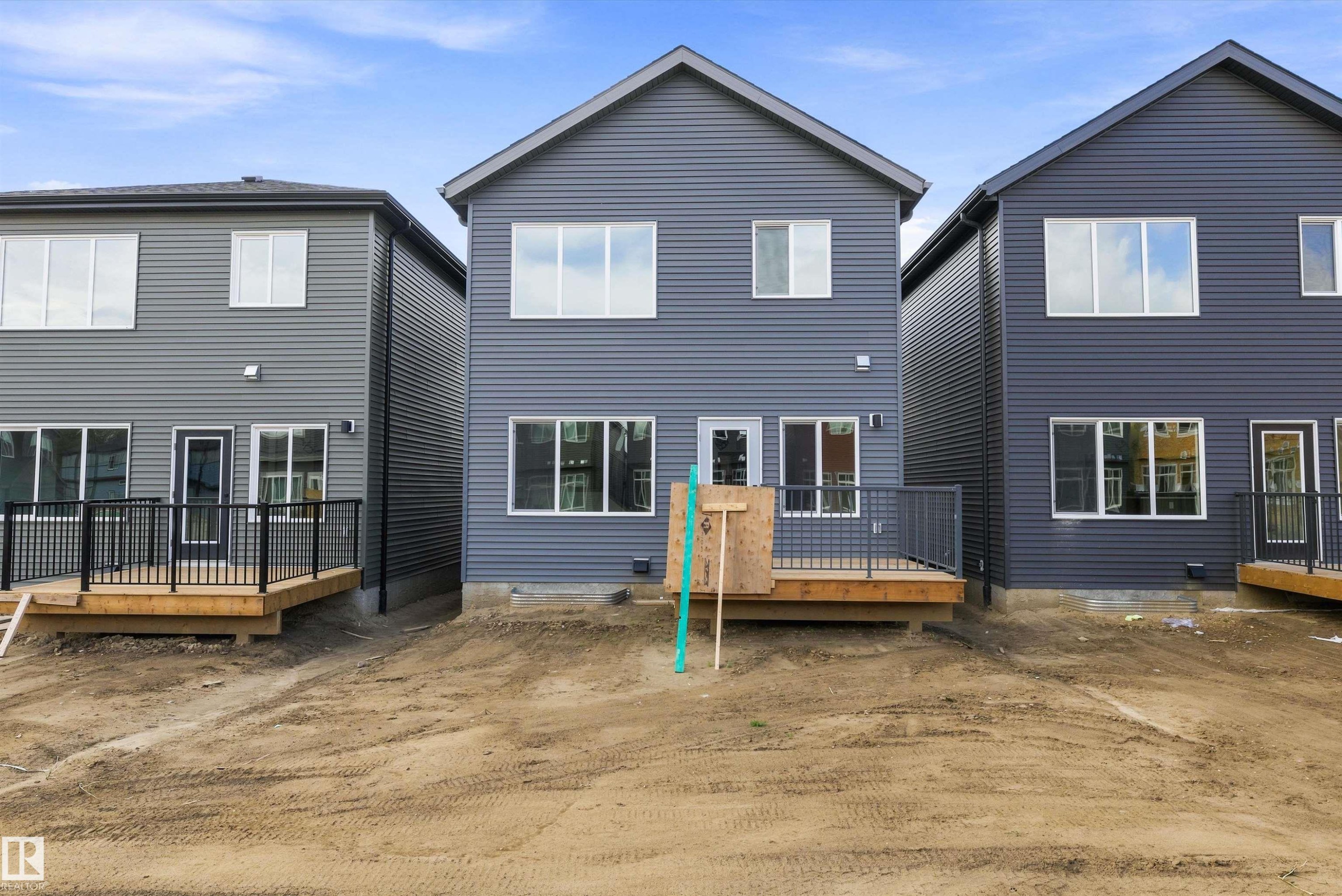 New construction townhomes featuring modern gray fiber cement siding, peaked rooflines, and multi-pane windows - 1776 Crossbill Loop Nw, Edmonton, AB