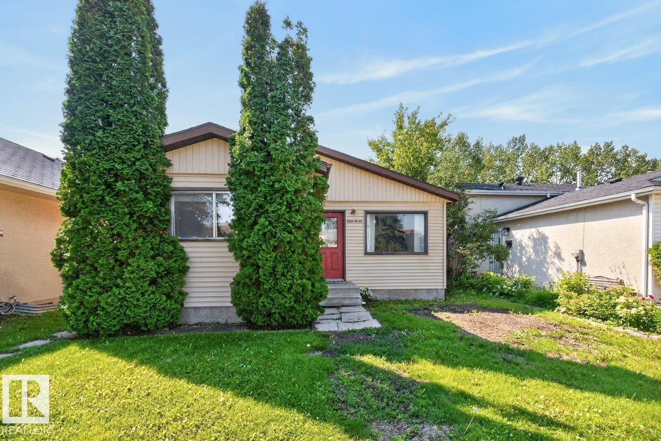 Front exterior featuring horizontal siding and a red entry door - 4003 41 Avenue Nw, Edmonton, AB - Outdoor