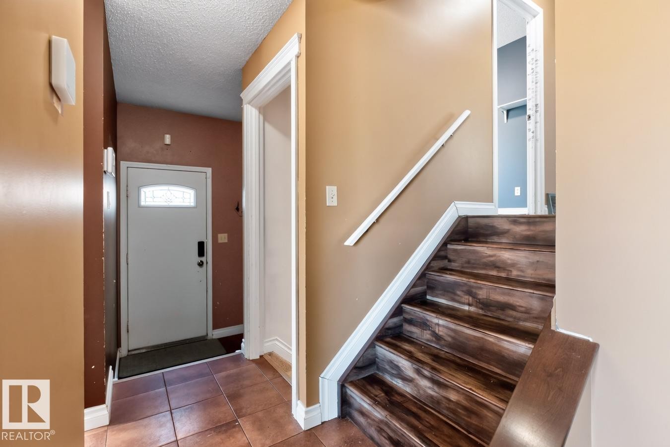 Entryway featuring terracotta-toned tile flooring and a white front door with an arched glass insert - 4003 41 Avenue Nw, Edmonton, AB - Indoor Photo Showing Other Room