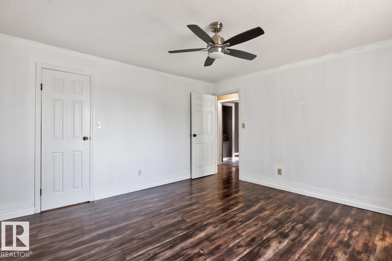 Spacious room featuring wood-finish flooring, crisp white walls, and a contemporary ceiling fan - 4003 41 Avenue Nw, Edmonton, AB - Indoor Photo Showing Other Room