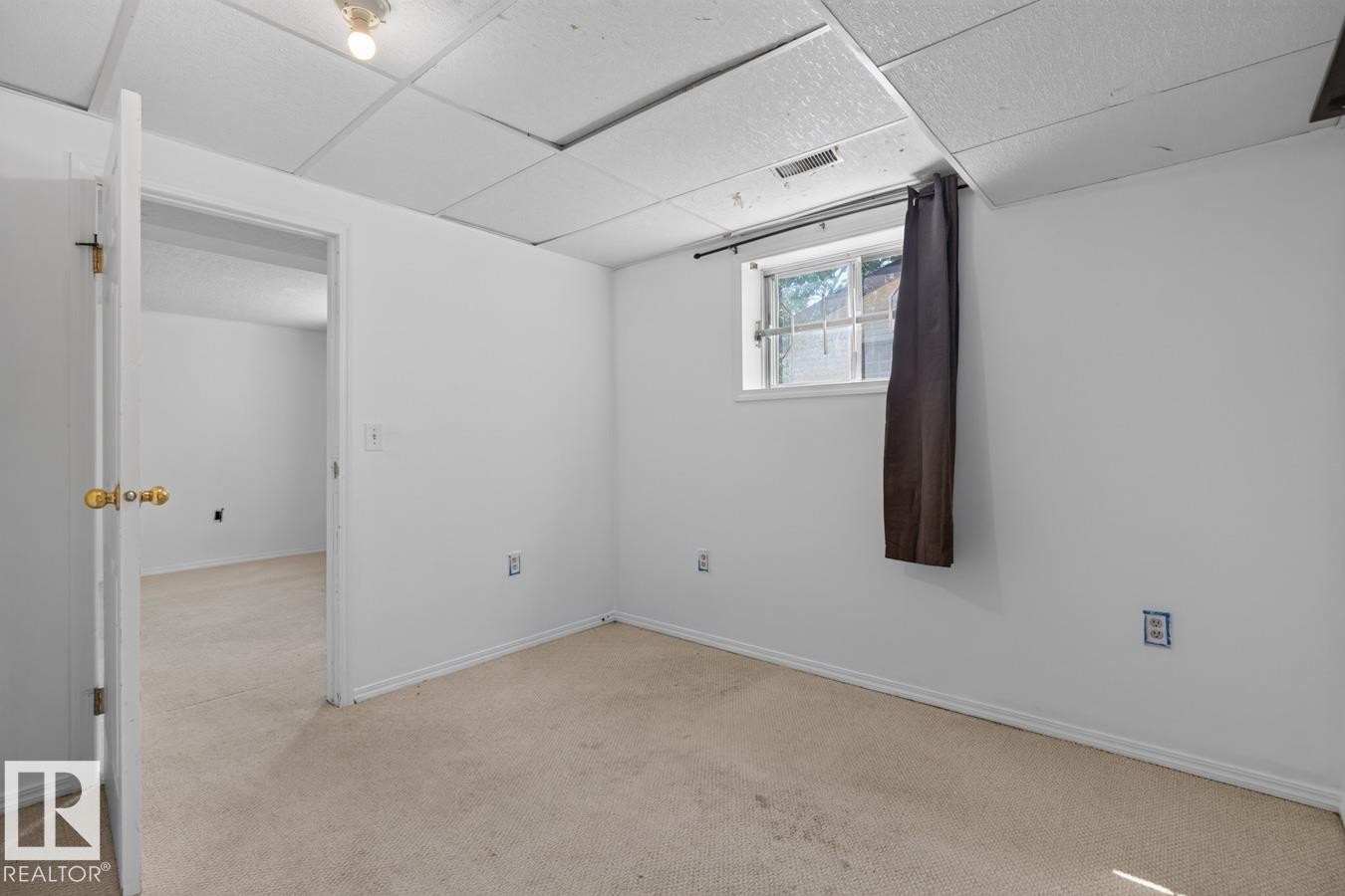 Carpeted room with white walls, a single-pane window, and a drop ceiling - 4003 41 Avenue Nw, Edmonton, AB - Indoor Photo Showing Other Room