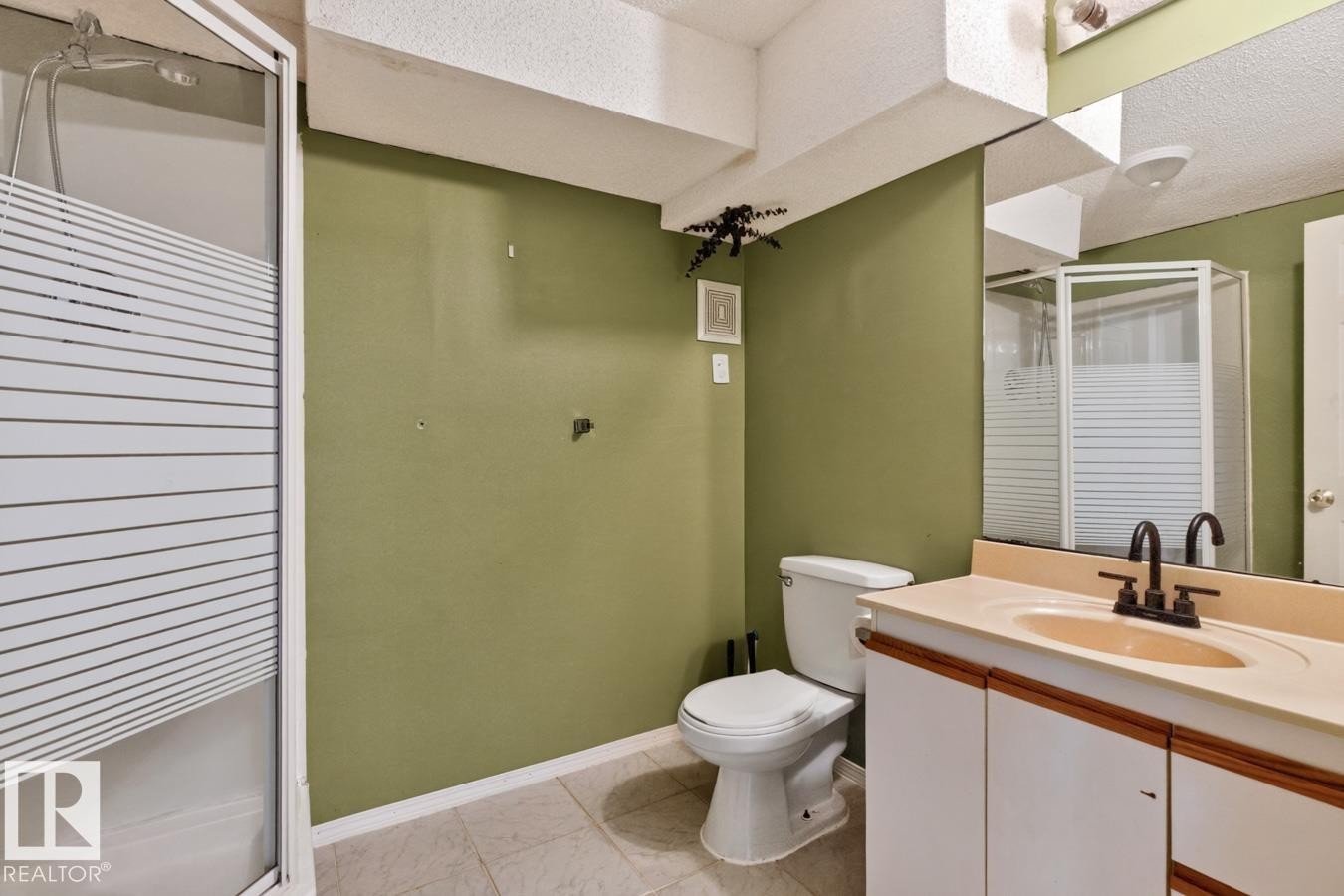 Bathroom with a white vanity featuring a built-in basin and matte black faucet, a toilet, and a stand-alone shower enclosure with frosted panels - 4003 41 Avenue Nw, Edmonton, AB - Indoor Photo Showing Bathroom
