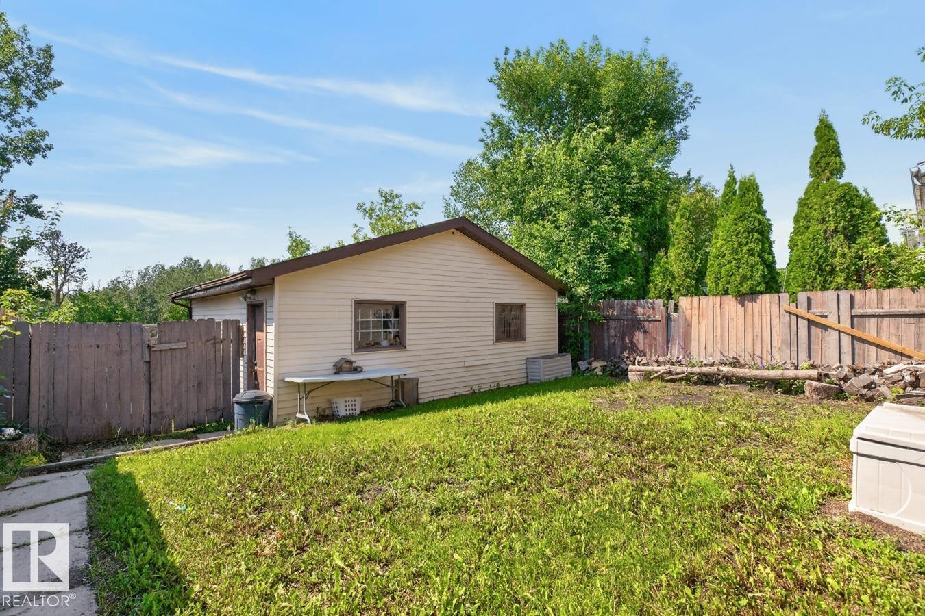 Expansive grassy yard with a beige-sided auxiliary building featuring a brown-trimmed roof - 4003 41 Avenue Nw, Edmonton, AB - Outdoor