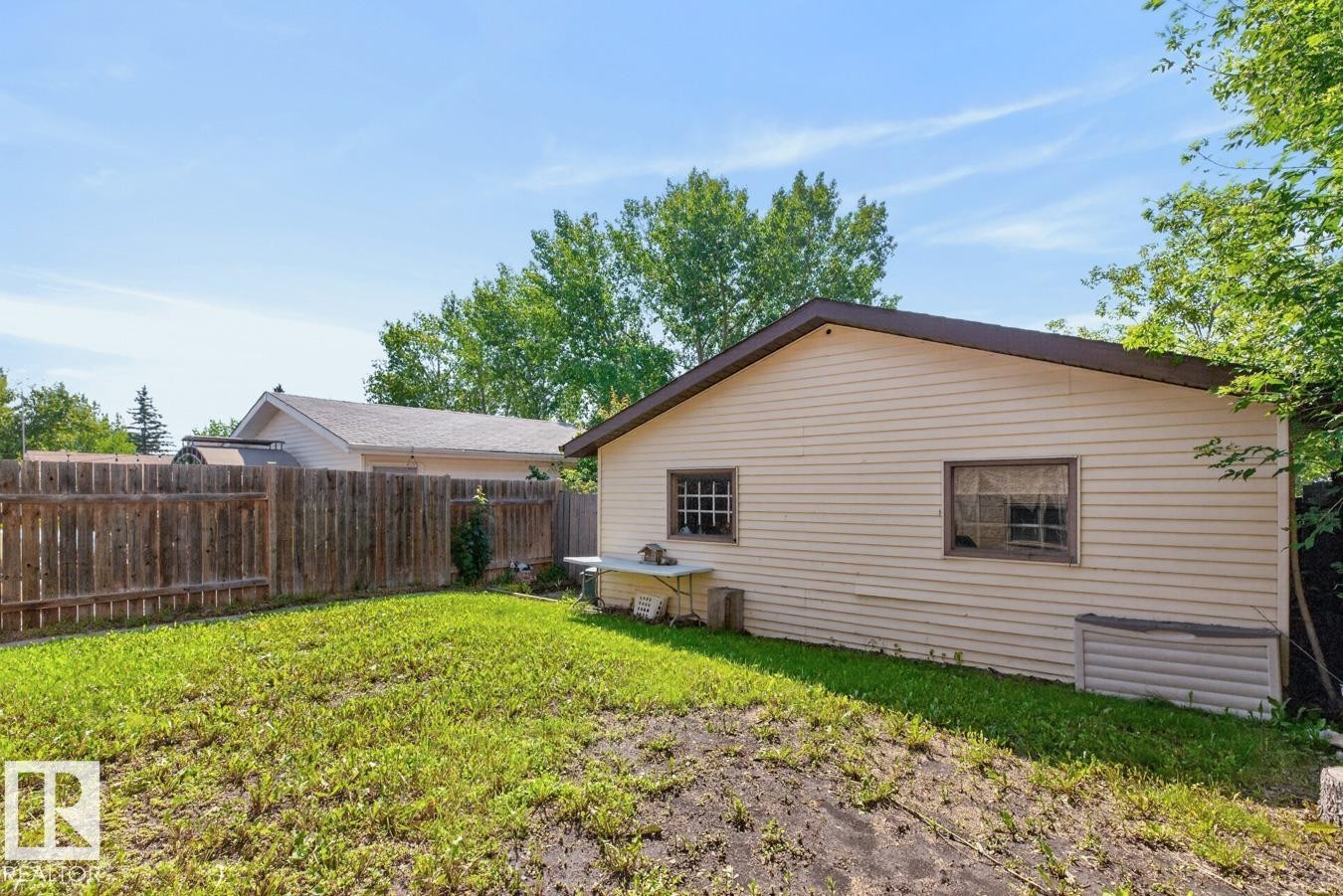 Rear yard featuring a detached structure with light-colored siding, a brown trimmed roof, and multiple windows - 4003 41 Avenue Nw, Edmonton, AB - Outdoor With Exterior