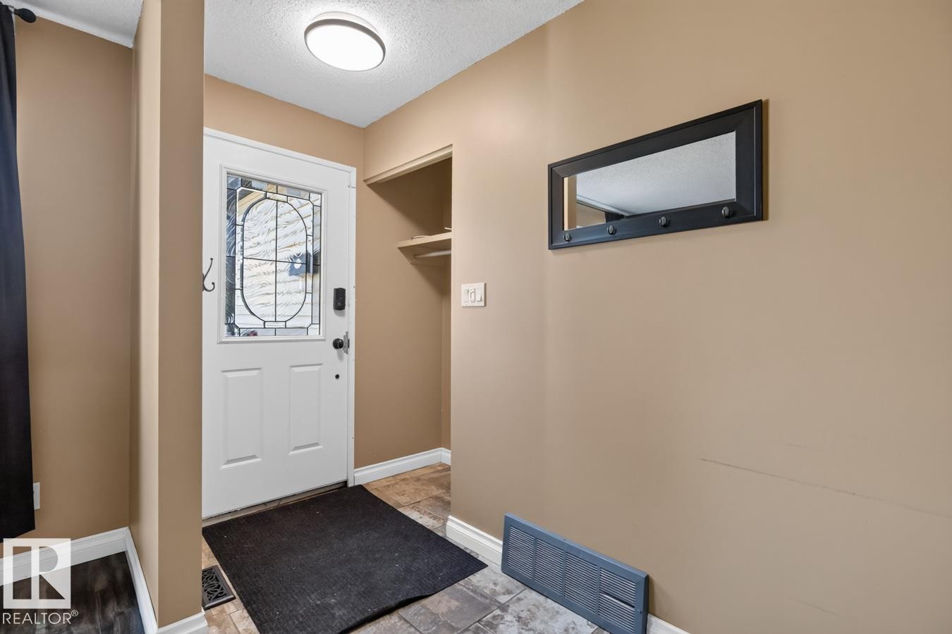 Entryway featuring a decorative glass-paneled door, sconce lighting, and a built-in storage nook - 4003 41 Avenue Nw, Edmonton, AB - Indoor Photo Showing Other Room