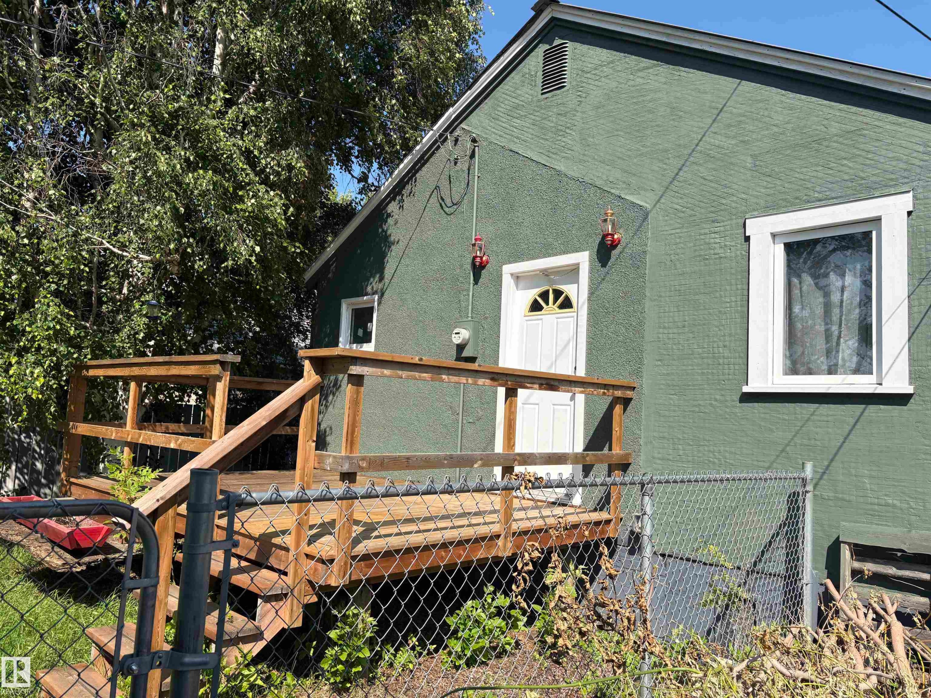 Green textured exterior with white trim windows and a white entry door - 4620 Maria Drive, Smoky Lake Town, AB - Outdoor With Deck Patio Veranda