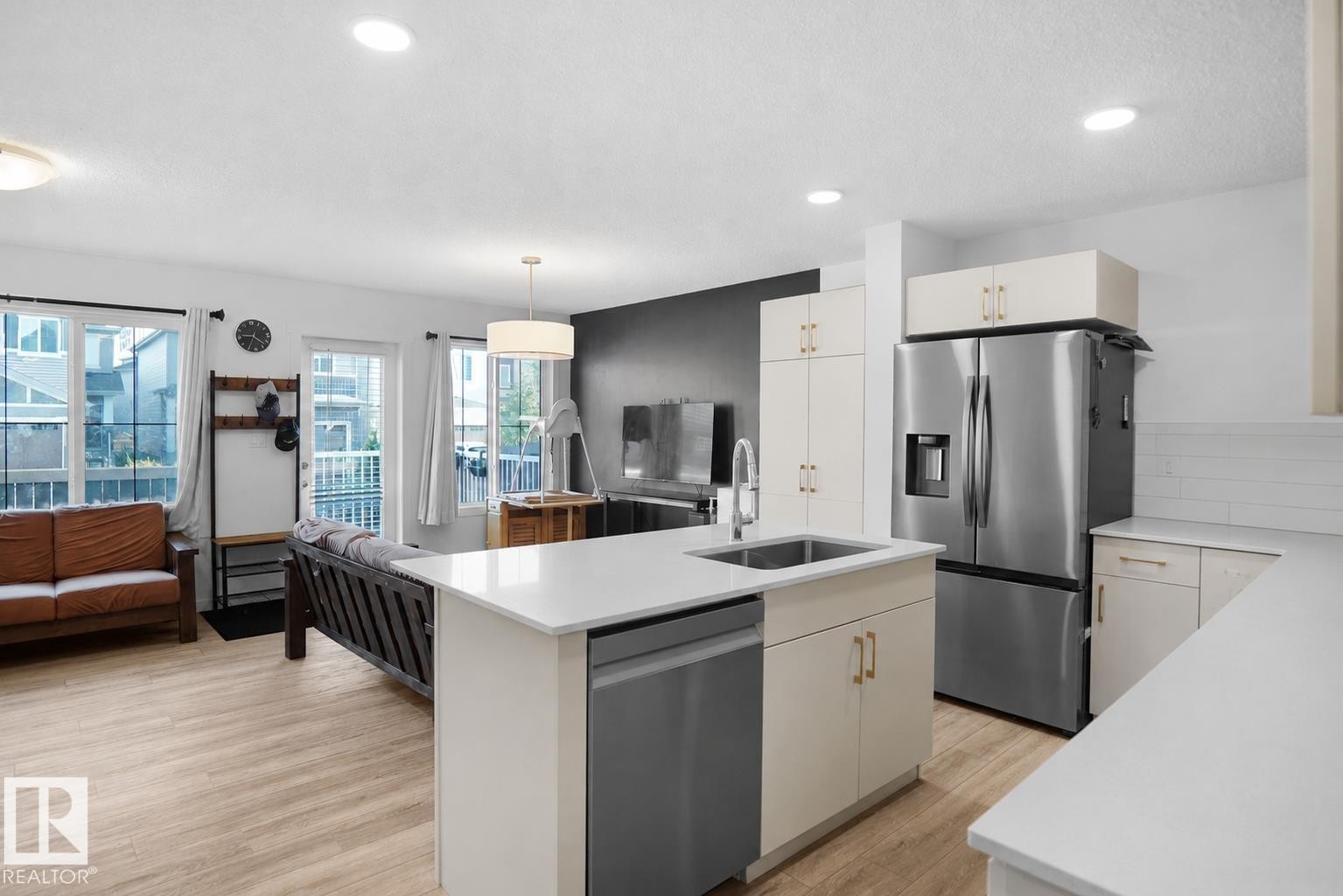Modern kitchen island with an undermount sink, quartz countertop, and stainless steel dishwasher - #42 19904 31 Av Nw, Edmonton, AB - Indoor Photo Showing Kitchen With Upgraded Kitchen
