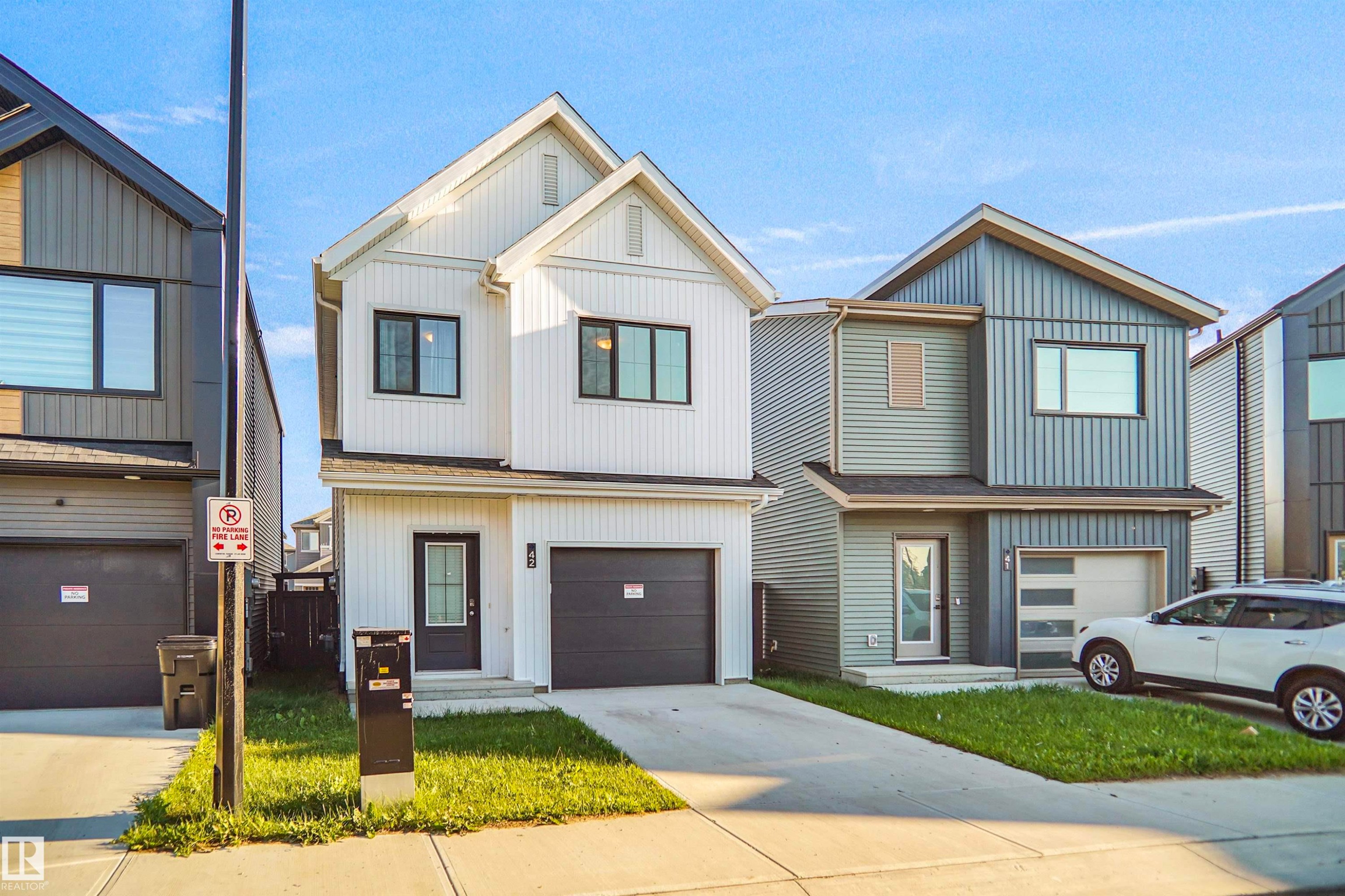 Contemporary two-story residence featuring white vertical siding and dark trim - #42 19904 31 Av Nw, Edmonton, AB - Outdoor With Facade