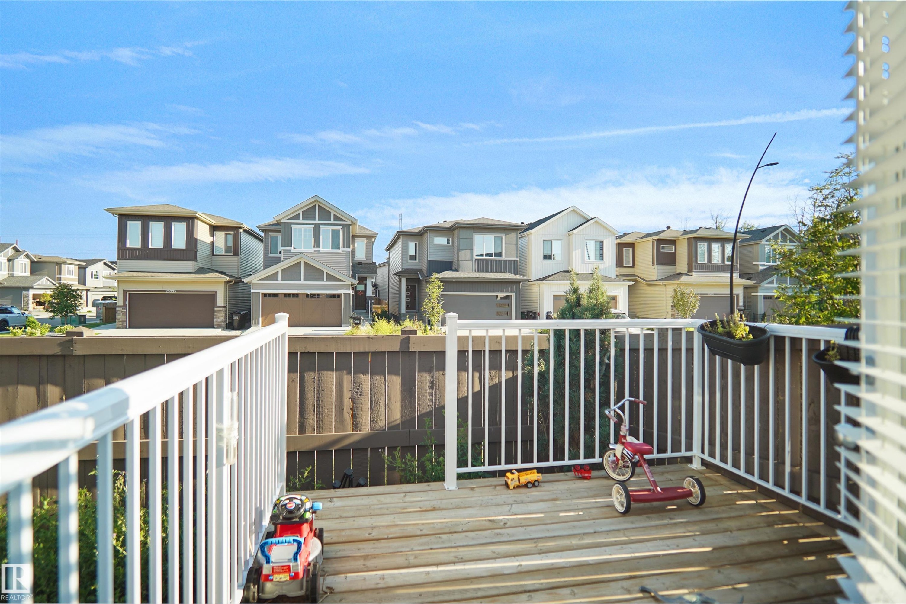 Exterior deck with white railing, featuring wood decking and a privacy fence - #42 19904 31 Av Nw, Edmonton, AB - Outdoor