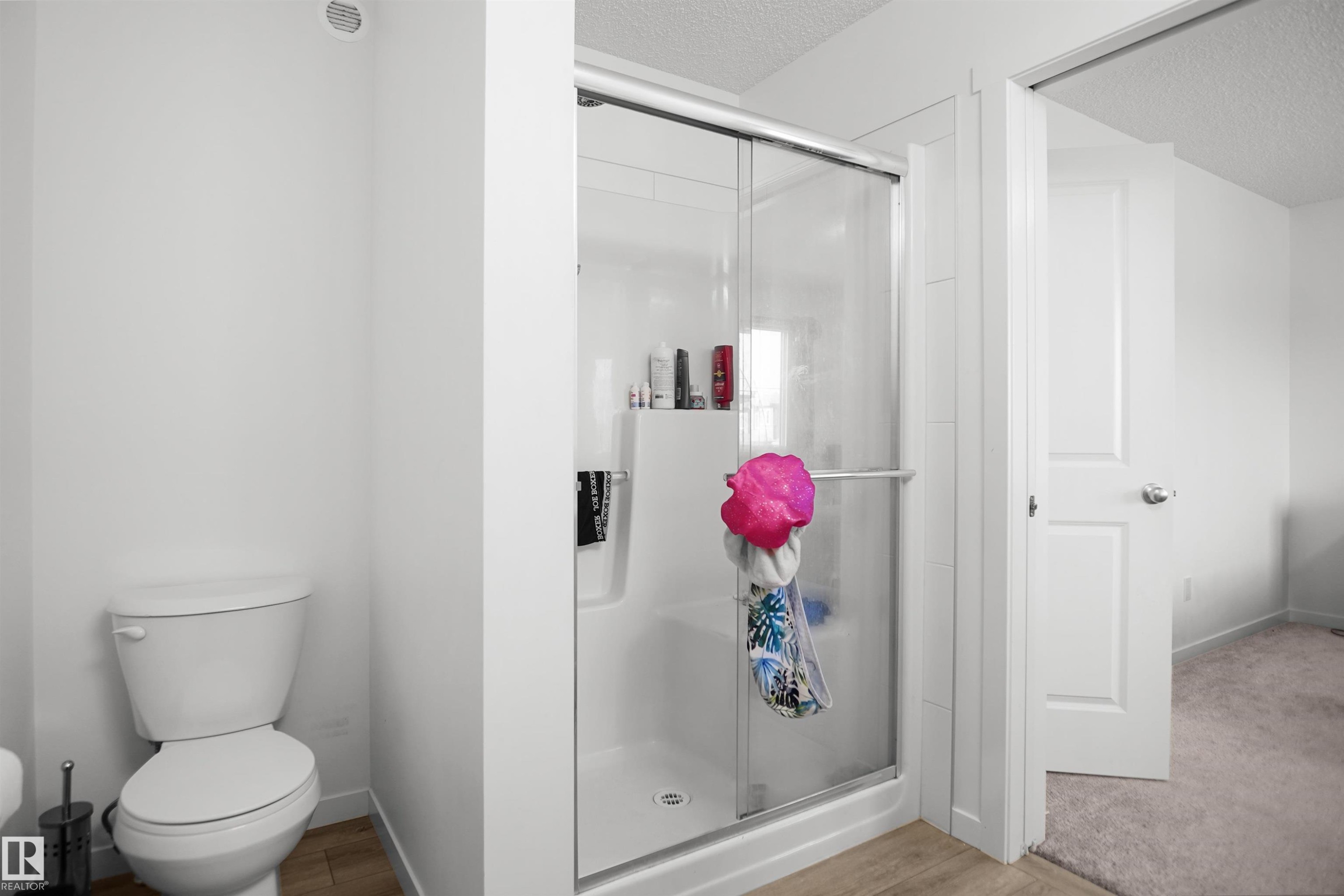 Modern shower enclosure with sliding glass door and integrated shelving - #42 19904 31 Av Nw, Edmonton, AB - Indoor Photo Showing Bathroom