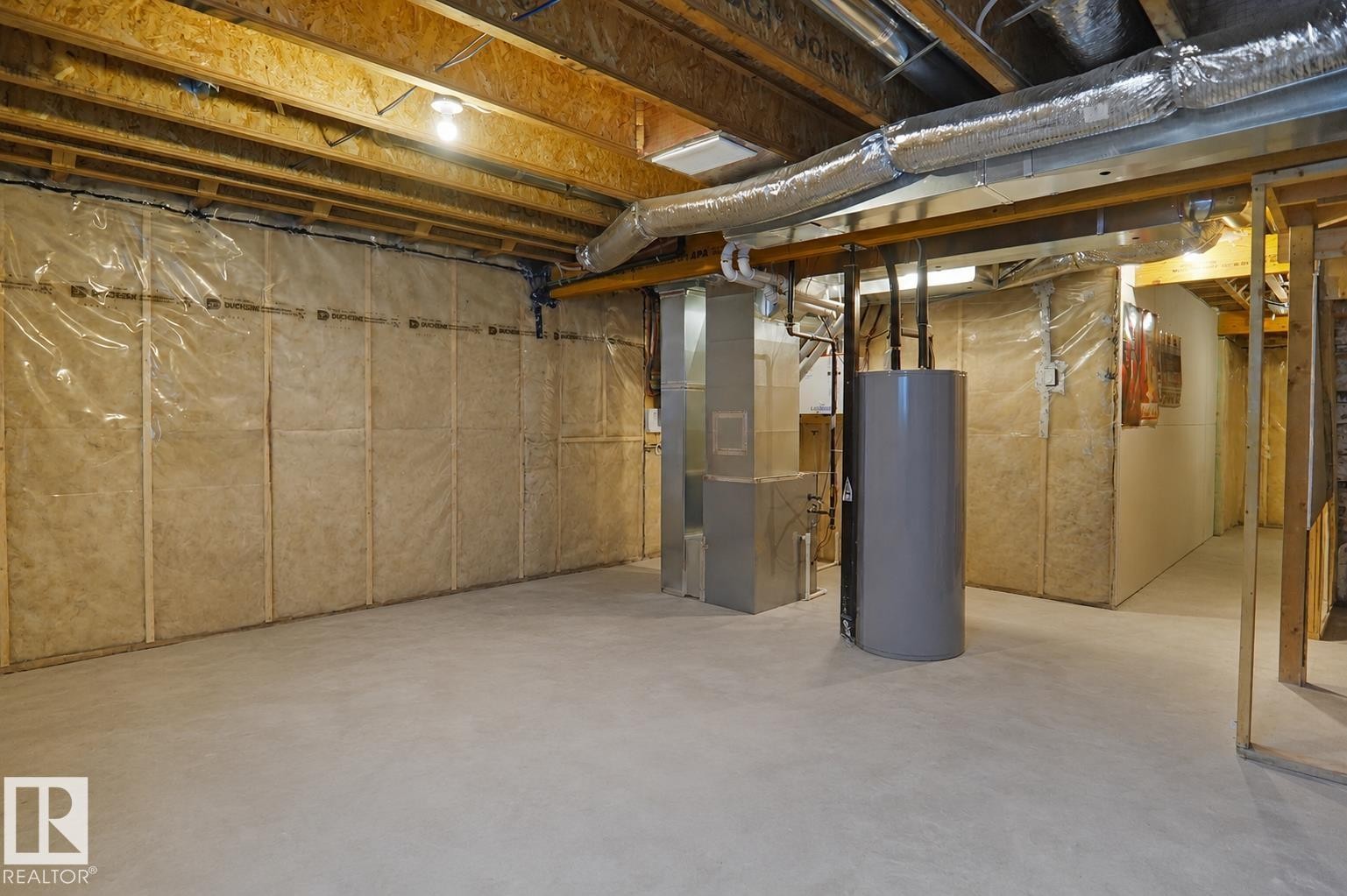 Unfinished lower level featuring exposed wood joists, concrete flooring, and insulated perimeter walls - #42 19904 31 Av Nw, Edmonton, AB - Indoor Photo Showing Basement