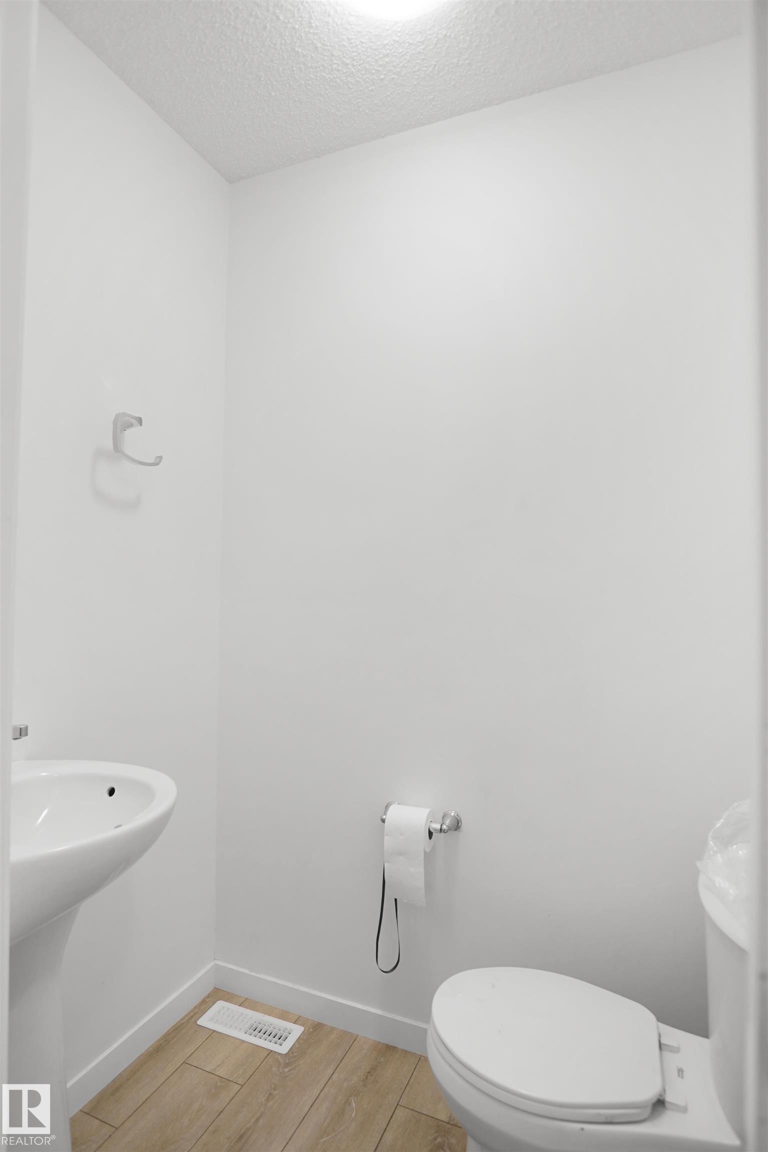 Pedestal sink and toilet with chrome fixtures - #42 19904 31 Av Nw, Edmonton, AB - Indoor Photo Showing Bathroom