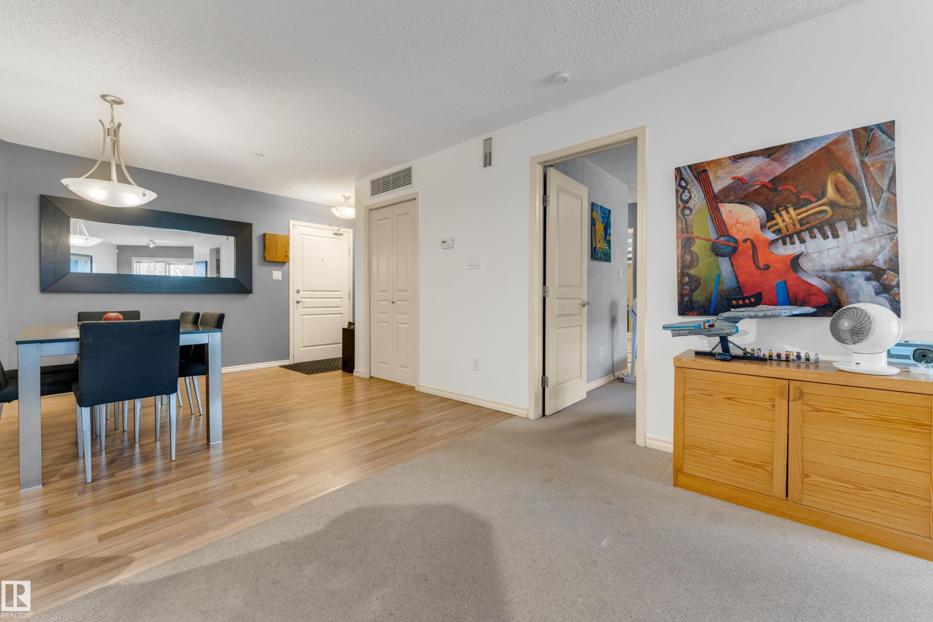 Open-concept living area featuring wood-finish flooring extending into the dining space - #136 16035 132 St Nw, Edmonton, AB - Indoor Photo Showing Dining Room