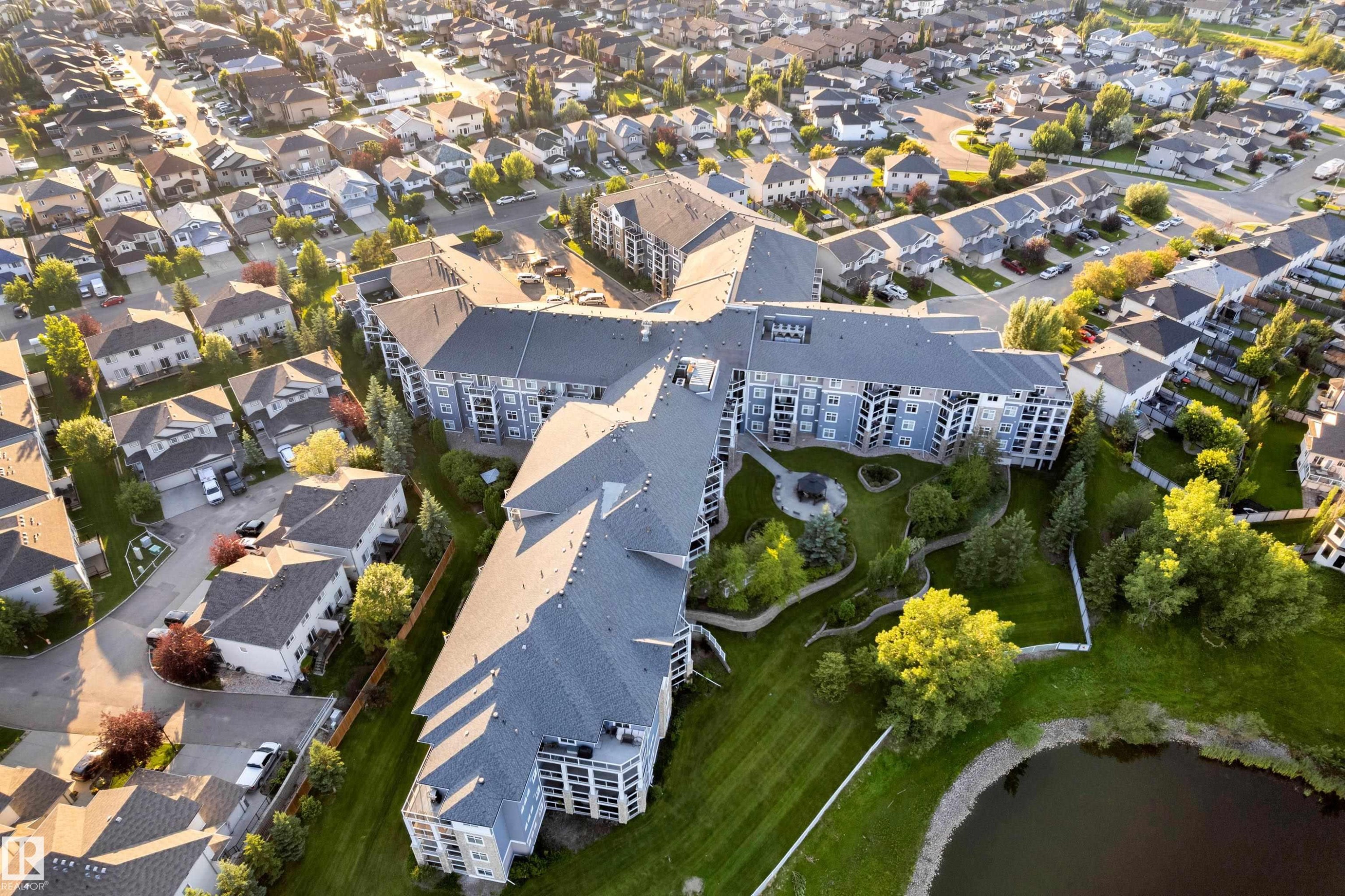Multi-story residential building featuring a light blue facade and multiple balconies - #136 16035 132 St Nw, Edmonton, AB - Outdoor With View
