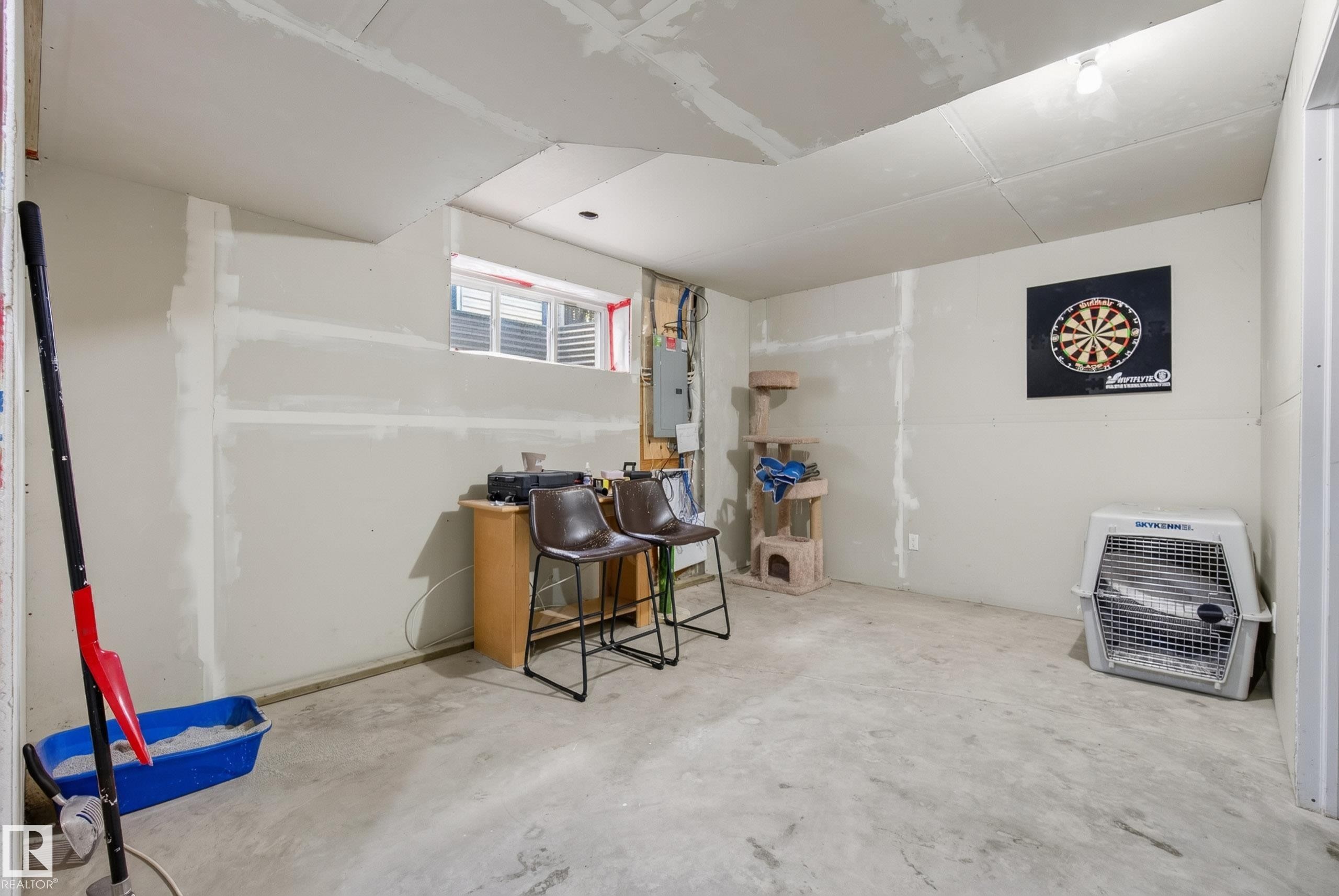 Unfinished basement featuring concrete flooring, partial drywall installation, and a single window for natural light - 3003 20 Avenue Nw, Edmonton, AB - Indoor