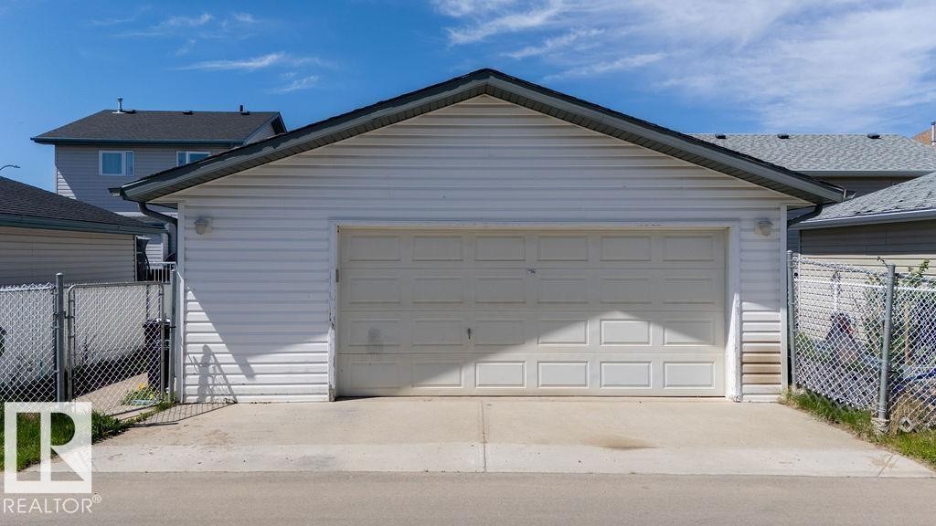 Detached garage with white horizontal siding and a single overhead door - 29 Campbell Road, Leduc, AB - Outdoor With Exterior