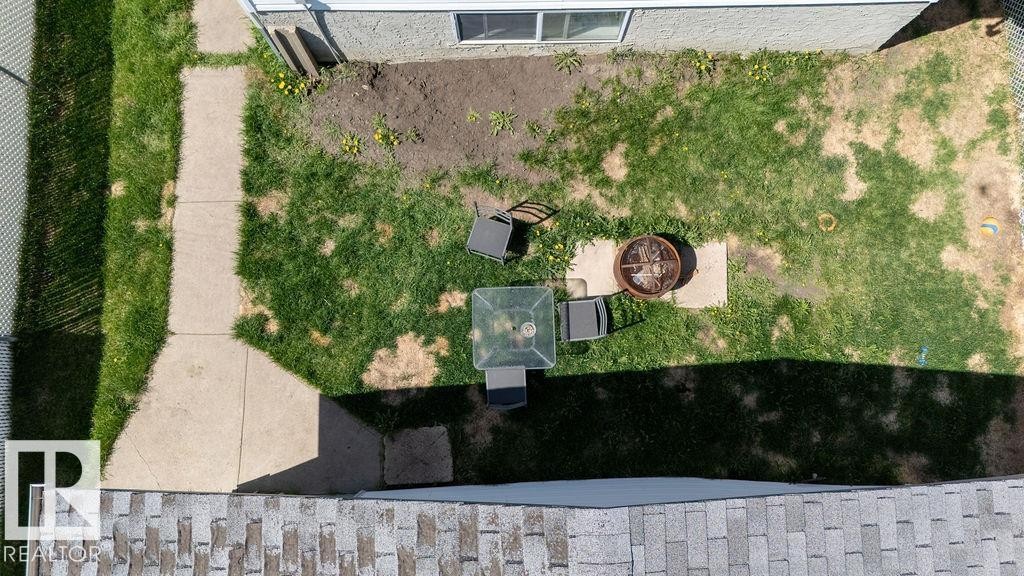 Private outdoor space featuring a concrete pathway, a fenced perimeter, and a fire pit area - 29 Campbell Road, Leduc, AB - Outdoor