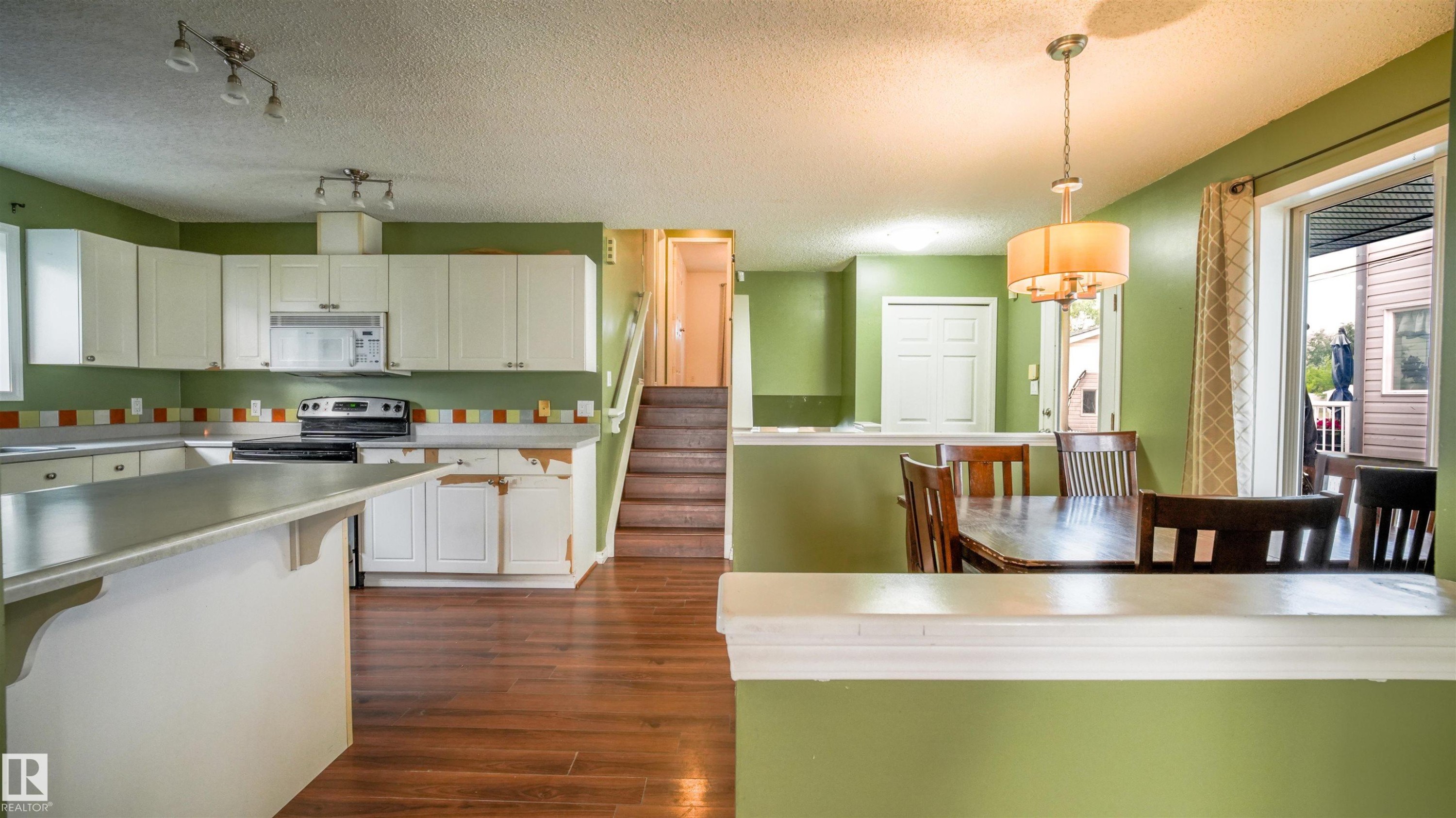 Kitchen with white cabinetry, a built-in microwave, and a black electric range - 29 Campbell Road, Leduc, AB - Indoor Photo Showing Kitchen With Double Sink