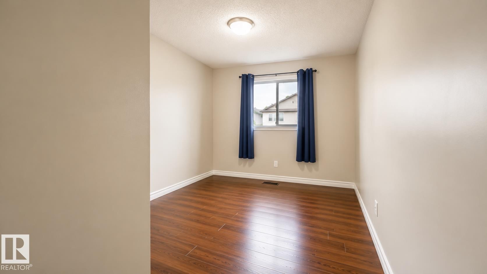 Interior room featuring wood-finish flooring, neutral wall tones, and white trim - 29 Campbell Road, Leduc, AB - Indoor Photo Showing Other Room