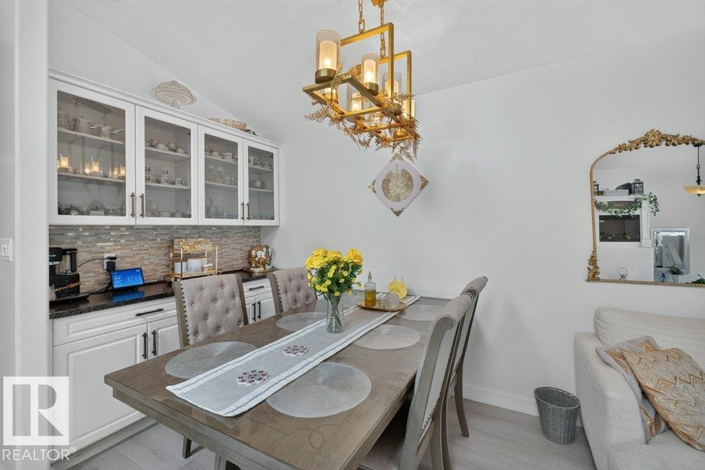 Recessed built-in cabinetry with glass-front upper cabinets and a tile backsplash - 12219 89 Street Nw, Edmonton, AB - Indoor Photo Showing Dining Room