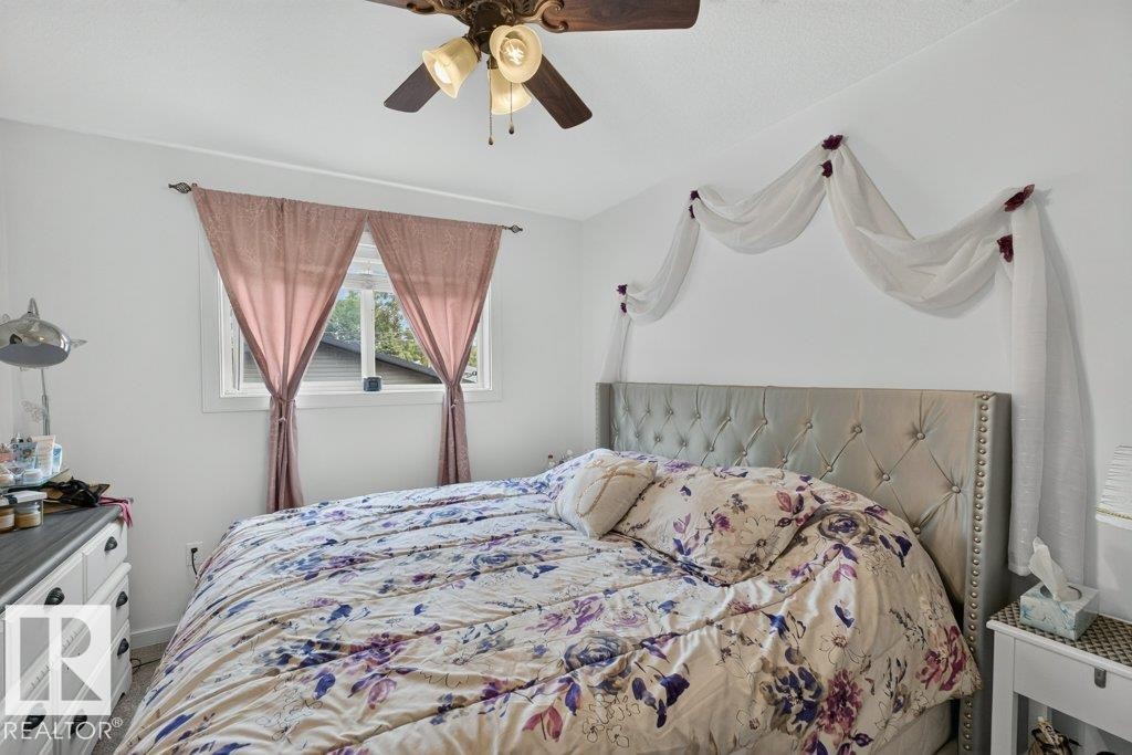 Bedroom featuring a ceiling fan, a window with natural light, and light-colored walls - 12219 89 Street Nw, Edmonton, AB - Indoor Photo Showing Bedroom