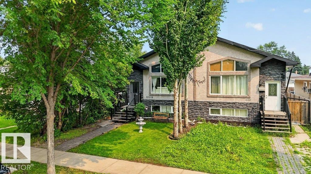 Stucco and stone facade property featuring multiple mature trees and a manicured lawn - 12219 89 Street Nw, Edmonton, AB - Outdoor
