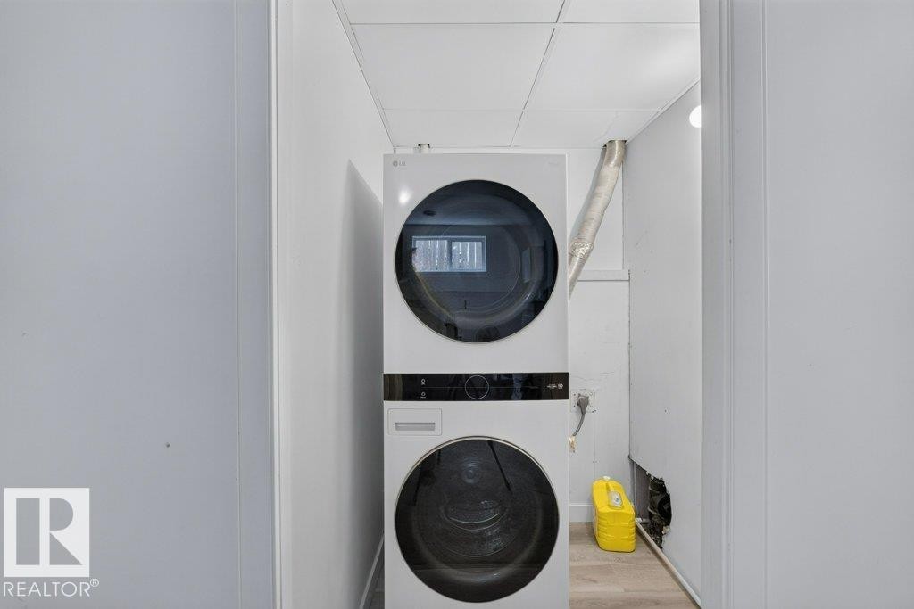 Dedicated laundry area featuring a stacked washer and dryer unit - 12219 89 Street Nw, Edmonton, AB - Indoor Photo Showing Laundry Room