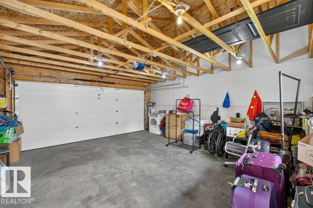 Spacious garage with exposed wood rafters and concrete flooring - 12219 89 Street Nw, Edmonton, AB - Indoor Photo Showing Garage