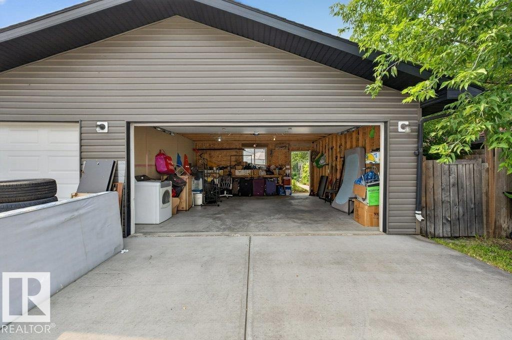 Two-door garage structure featuring gray horizontal siding, a dark roofline, and concrete driveway - 12219 89 Street Nw, Edmonton, AB - Outdoor With Exterior