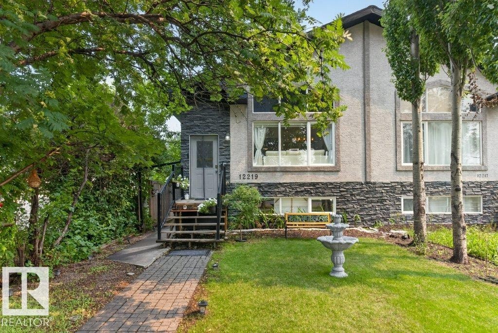 Stucco and stone facade featuring multiple large windows and a covered front entry with stairs - 12219 89 Street Nw, Edmonton, AB - Outdoor
